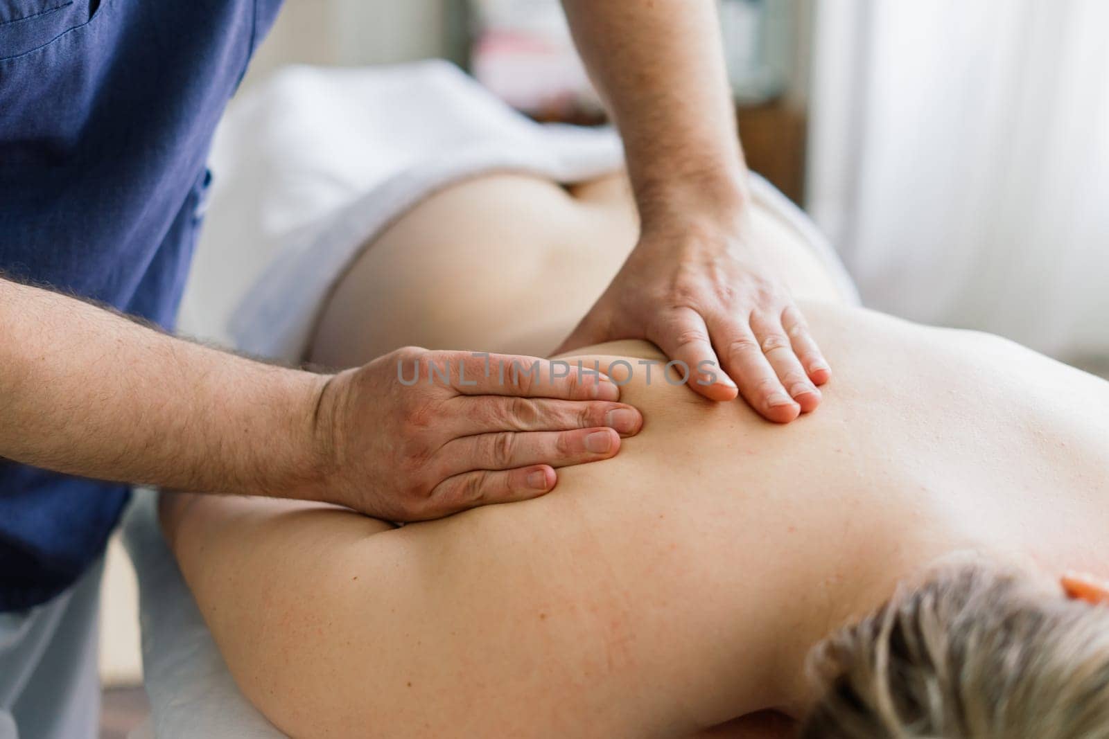 Young fat woman getting massage treatment in day spa cabinet. by Zelenin