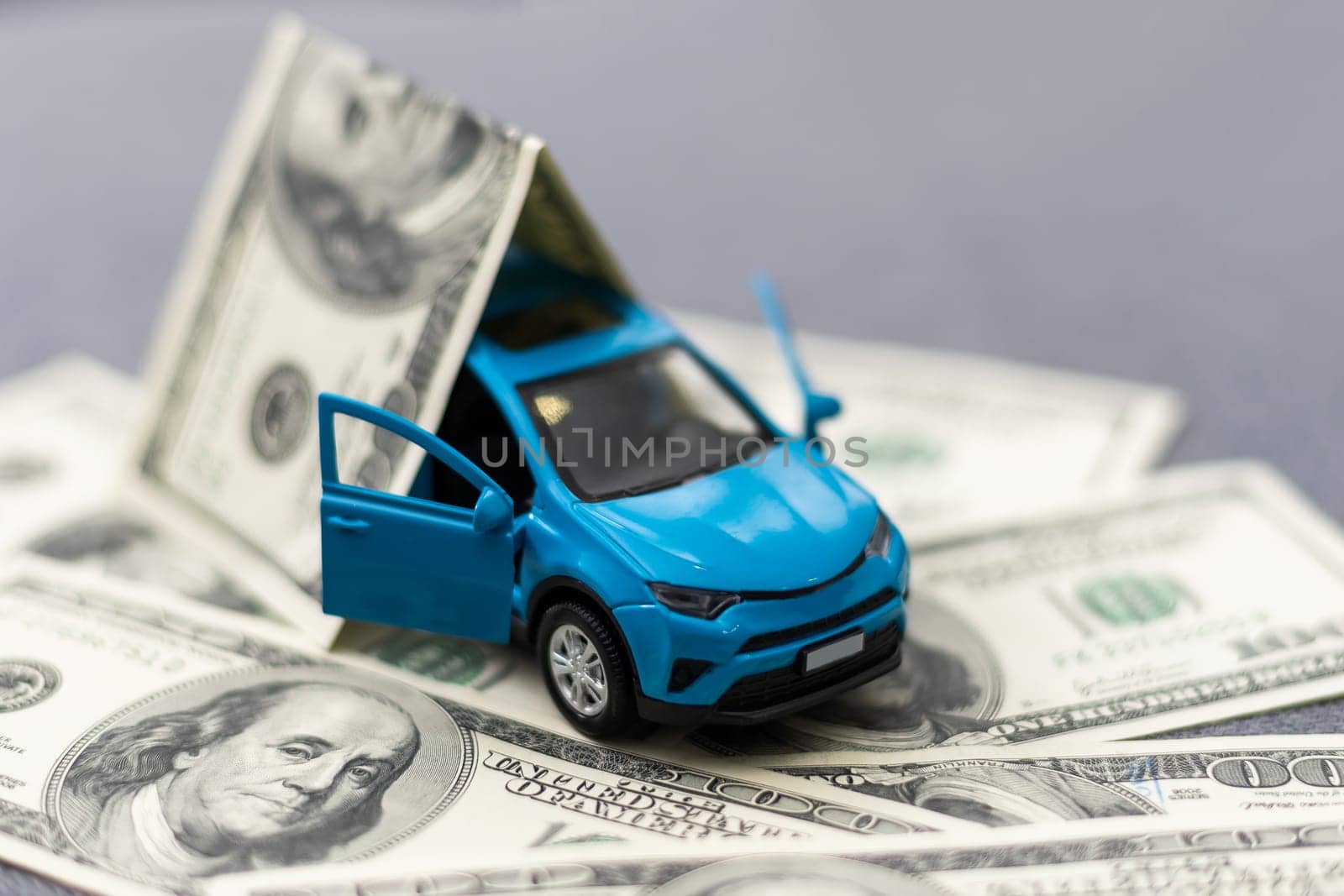 Toy car and money over white. Rent, buy or insurance car concept by Andelov13