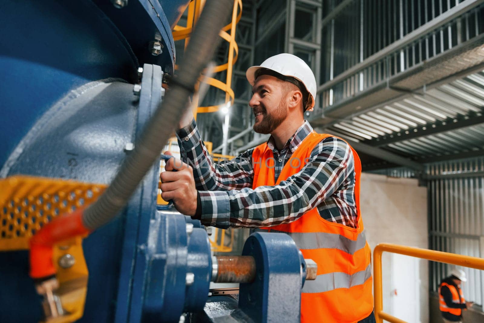 Professional construction worker in uniform is in the factory.