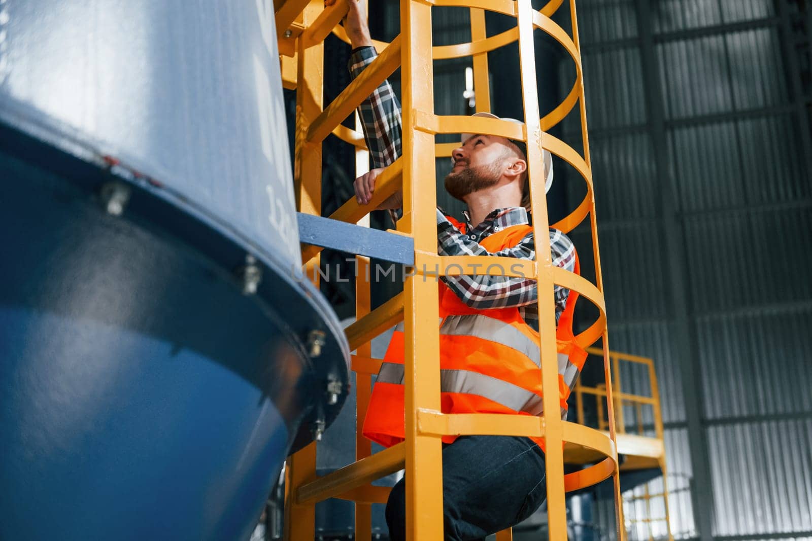 Professional construction worker in uniform is in the factory.