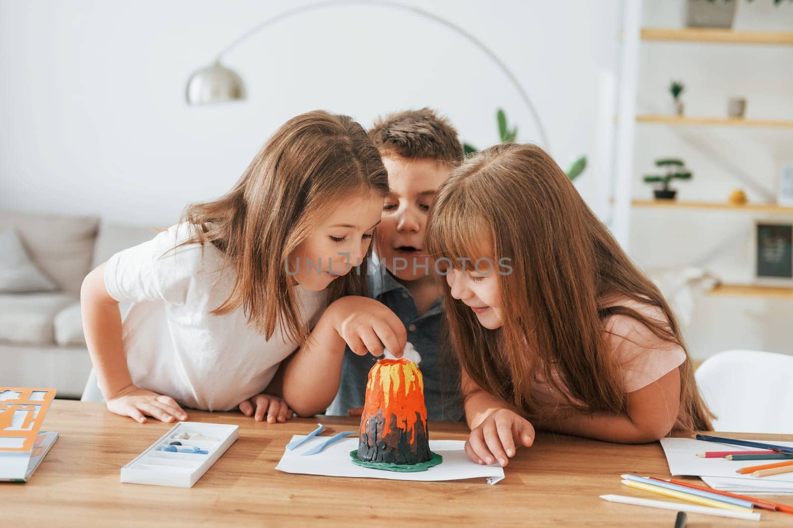 Working on the volcano project. Kids having fun in the domestic room at daytime together.