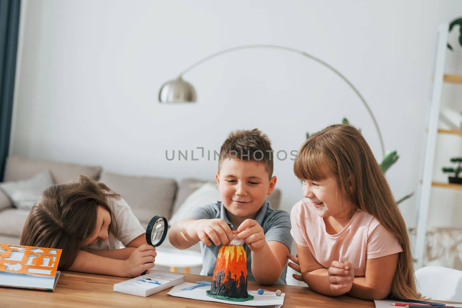 Working on the volcano project. Kids having fun in the domestic room at daytime together.
