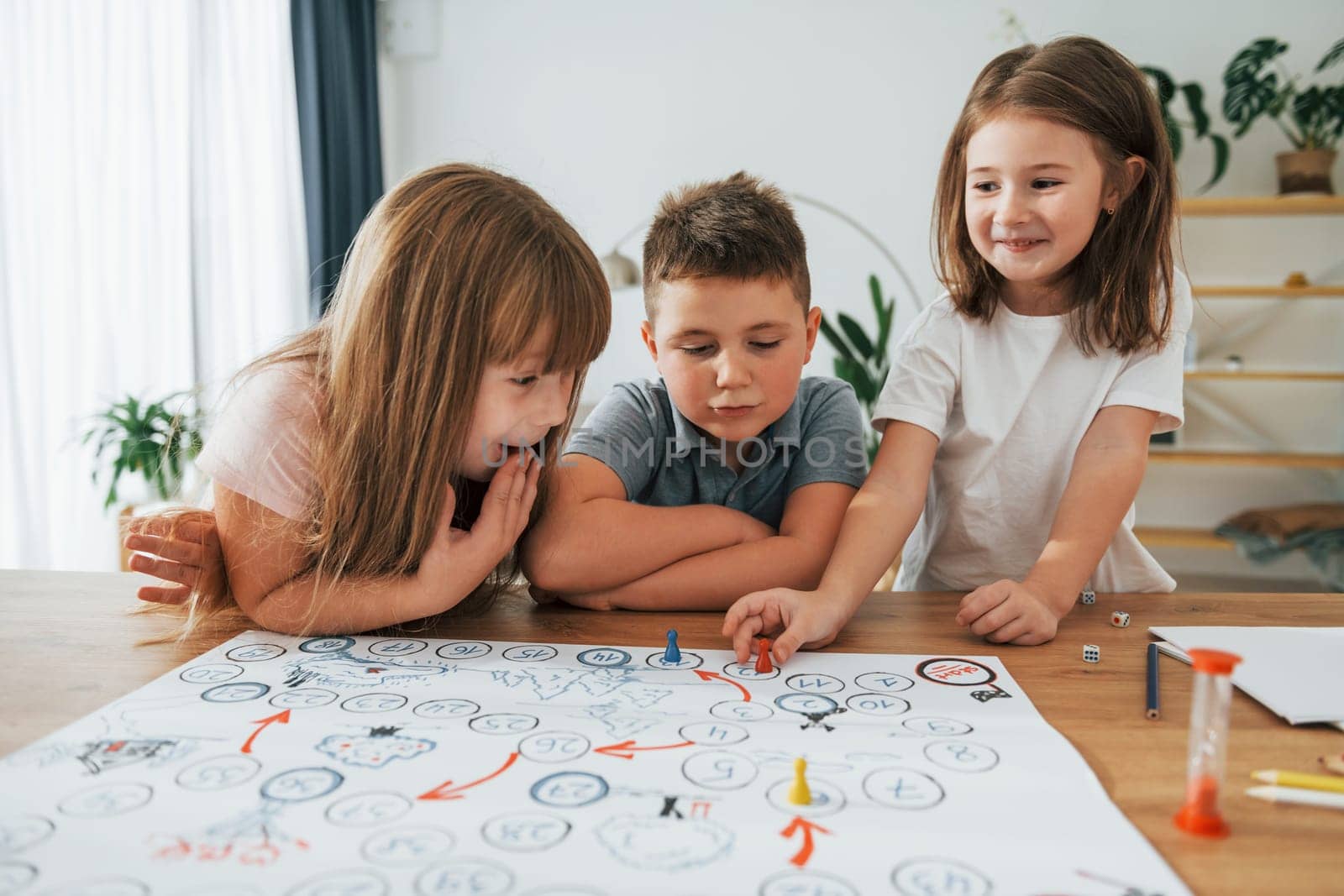 Playing game together. Kids having fun in the domestic room at daytime.