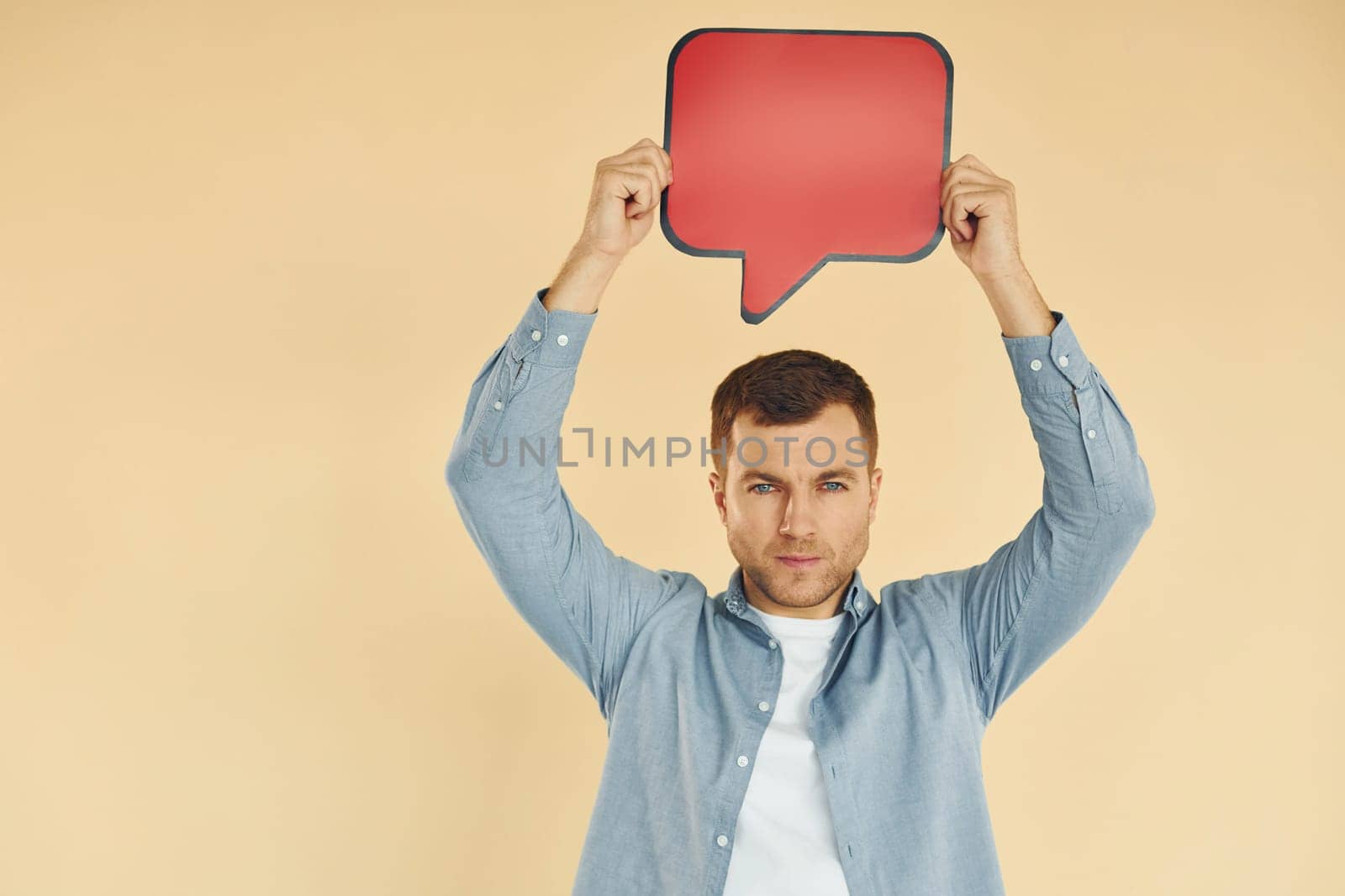 Facial expression. Man standing in the studio with empty signs for the text.