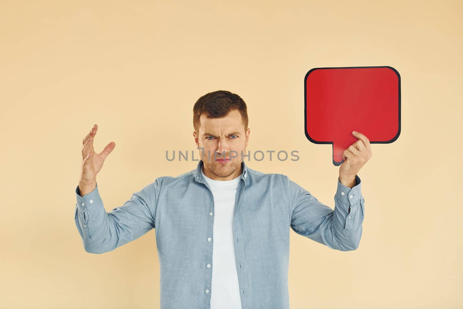Angry and mad. Man standing in the studio with empty signs for the text.