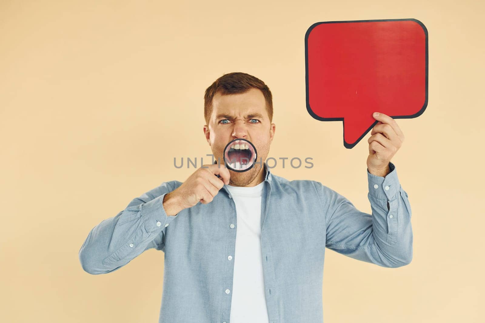 Angry and mad. Man standing in the studio with empty signs for the text.
