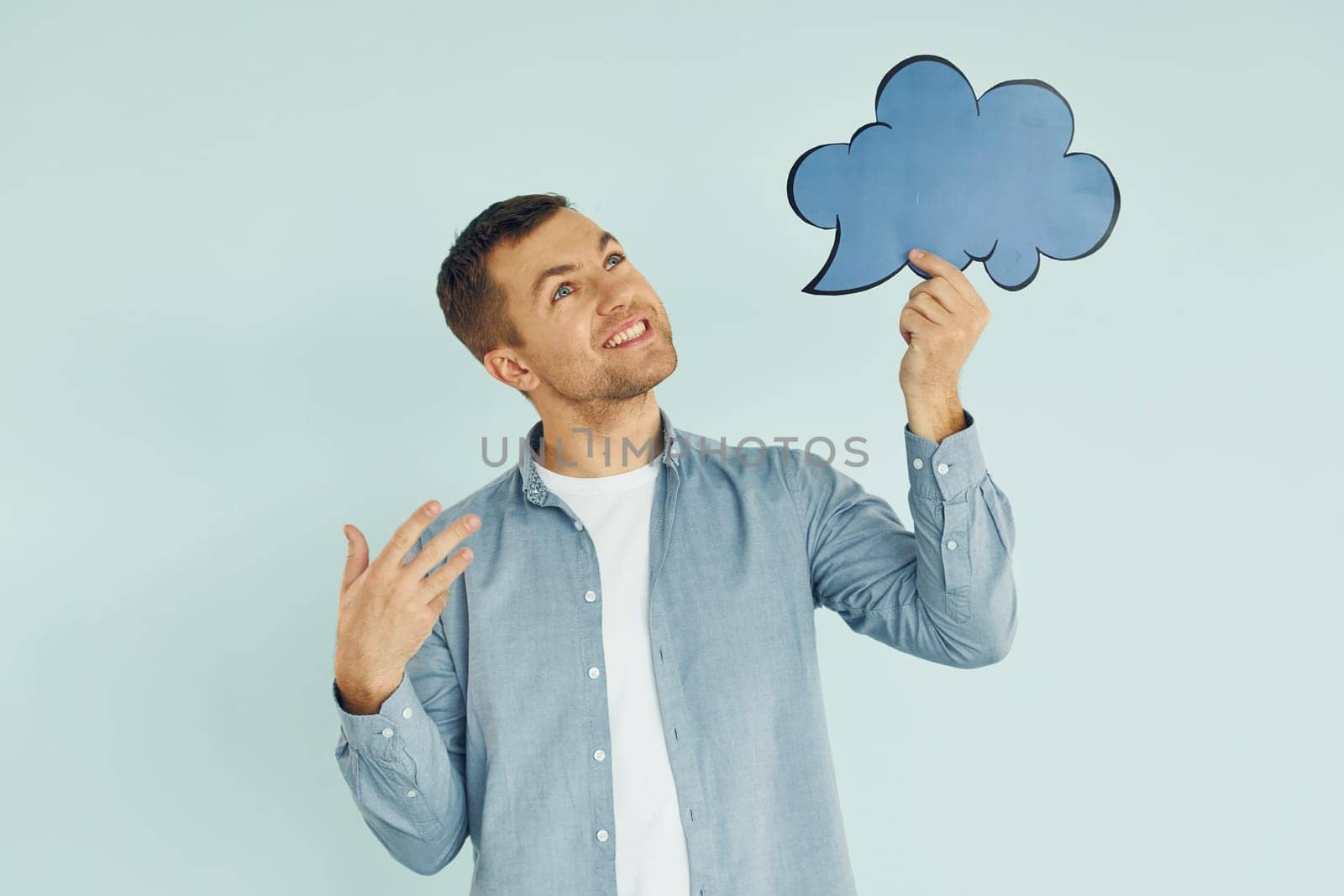 Holding sign. Man standing in the studio.