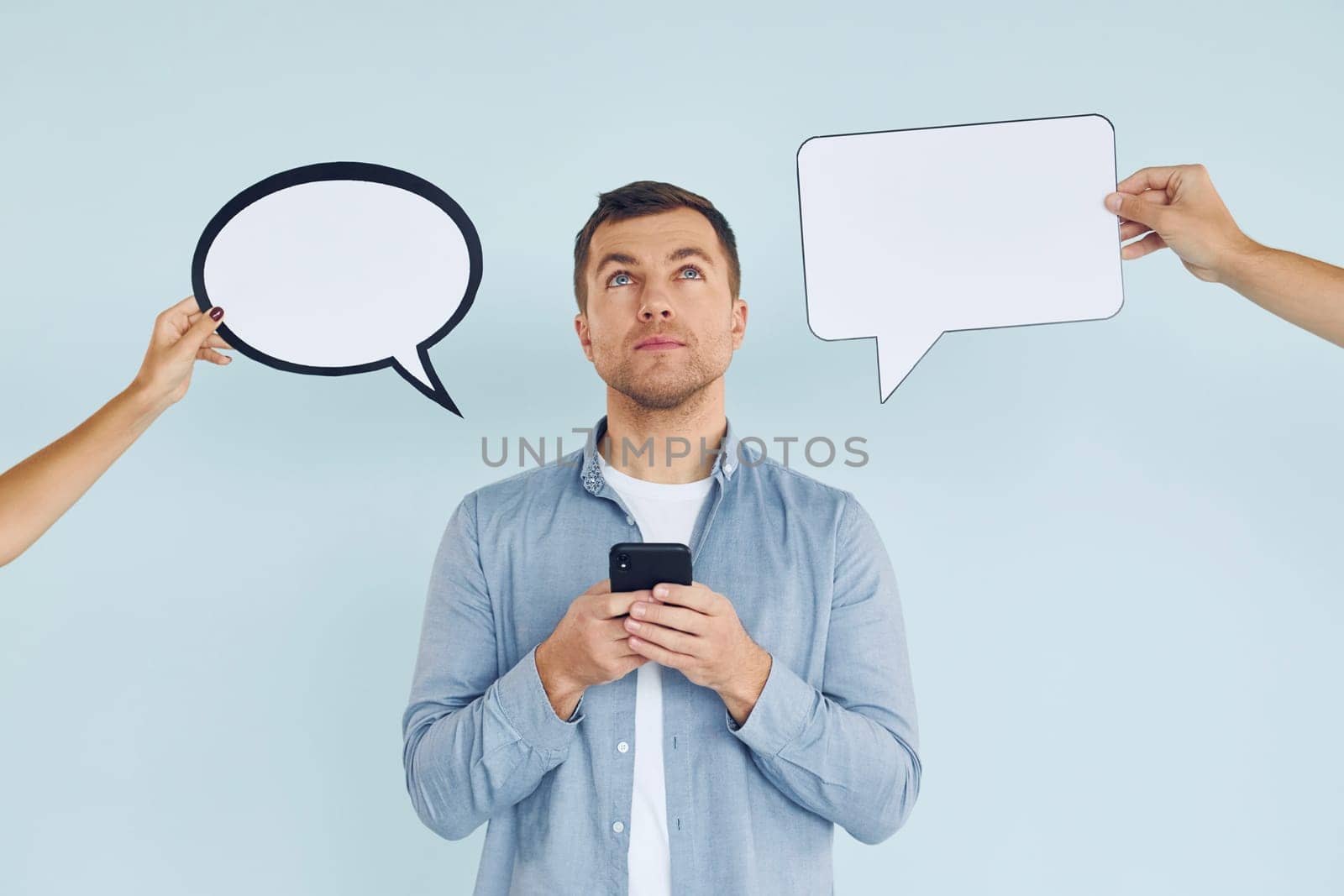 Thinking what to answer. Man standing in the studio with empty signs for the text.
