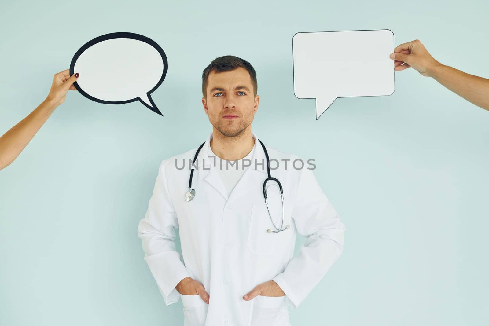 In doctor's uniform. Man standing in the studio with empty signs for the text.
