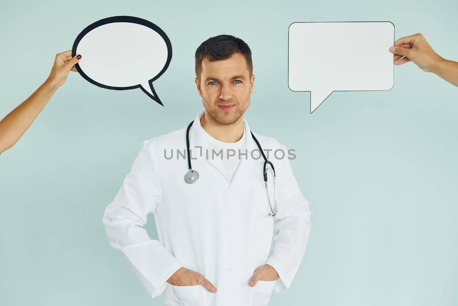 In doctor's uniform. Man standing in the studio with empty signs for the text.