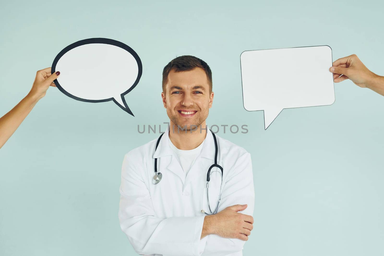 In doctor's uniform. Man standing in the studio with empty signs for the text.