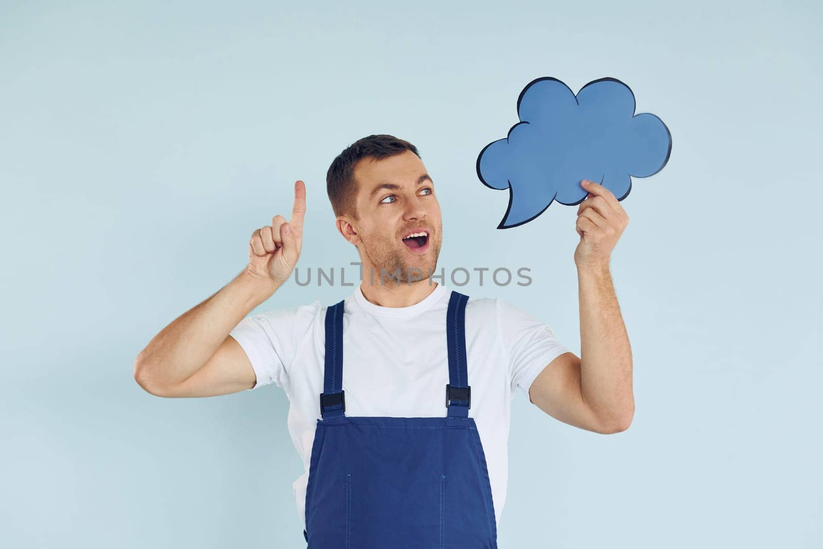 Worker in uniform. Man standing in the studio with empty signs for the text.