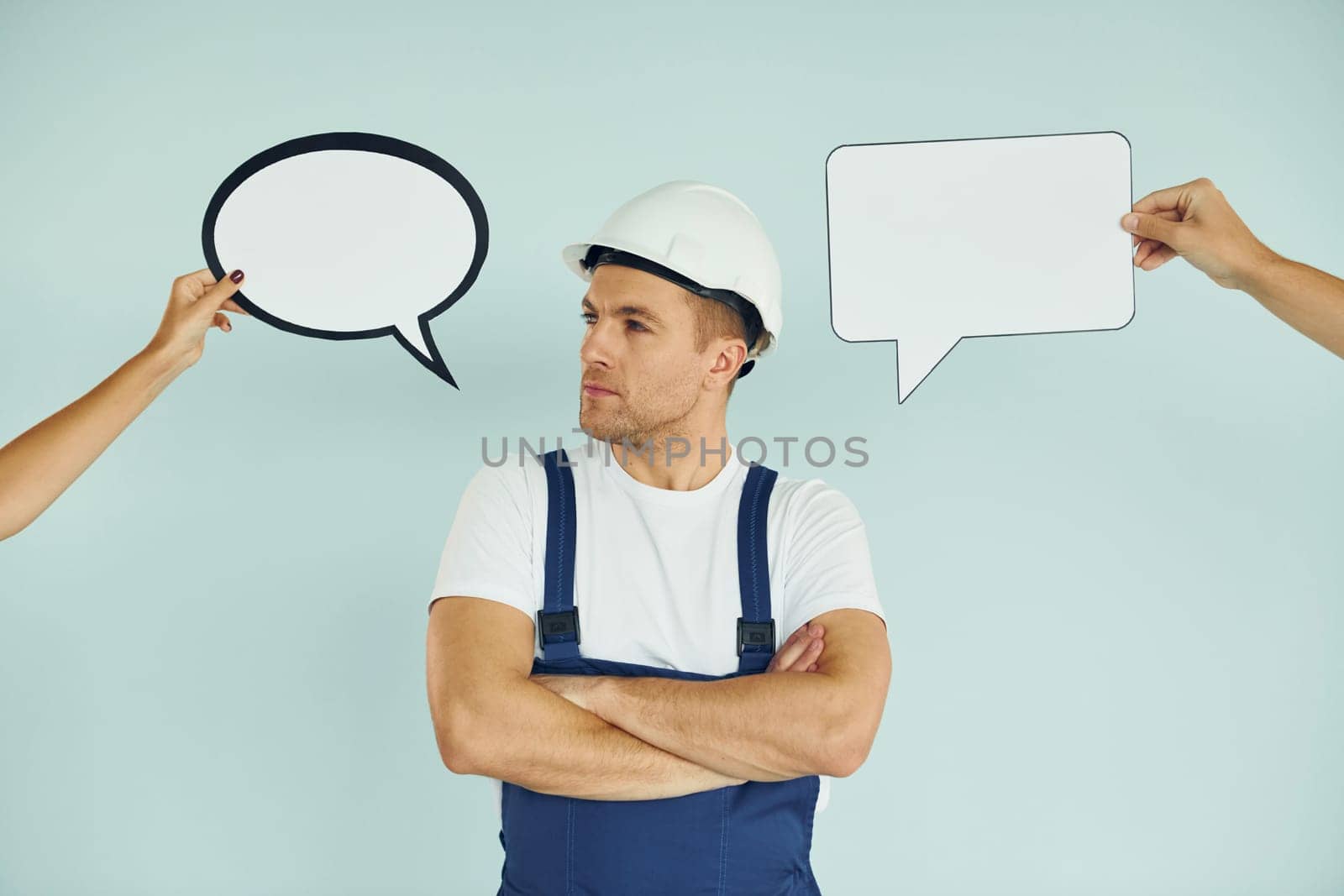 Worker is thinking. Man standing in the studio with empty signs for the text.