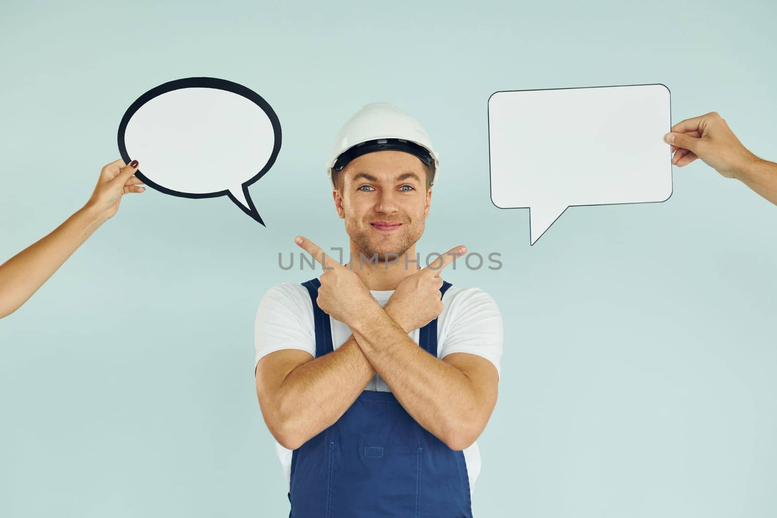 White hard hat and blue uniform. Man standing in the studio with empty signs for the text.