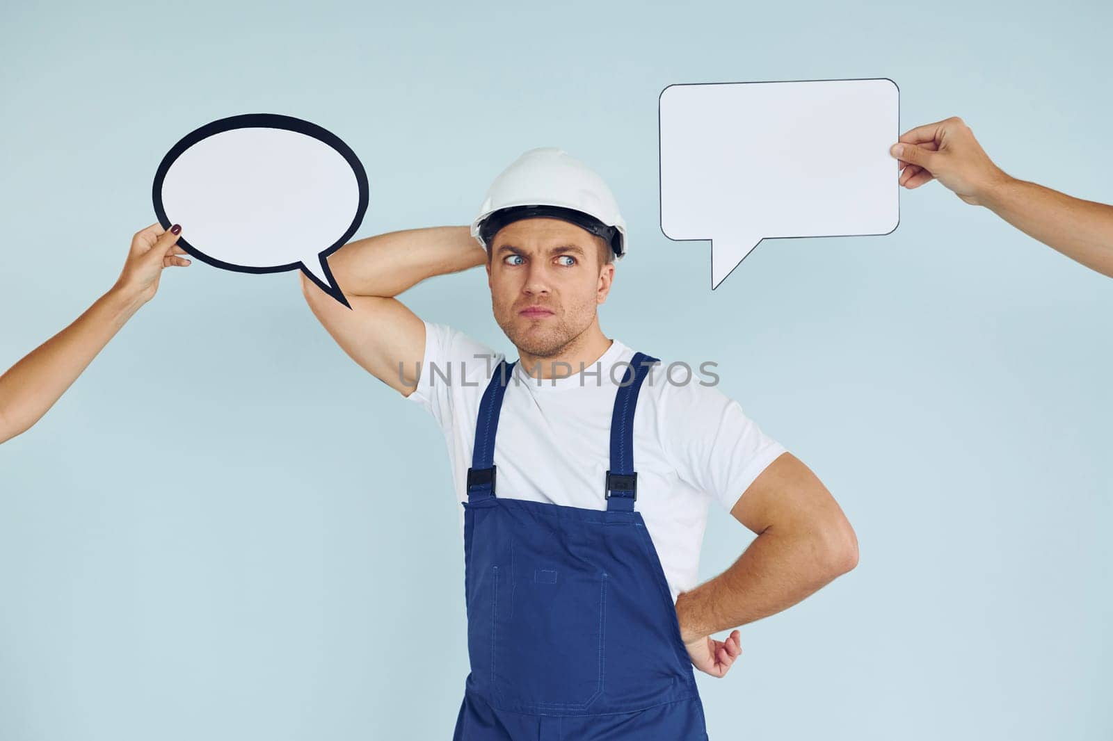 White hard hat and blue uniform. Man standing in the studio with empty signs for the text.