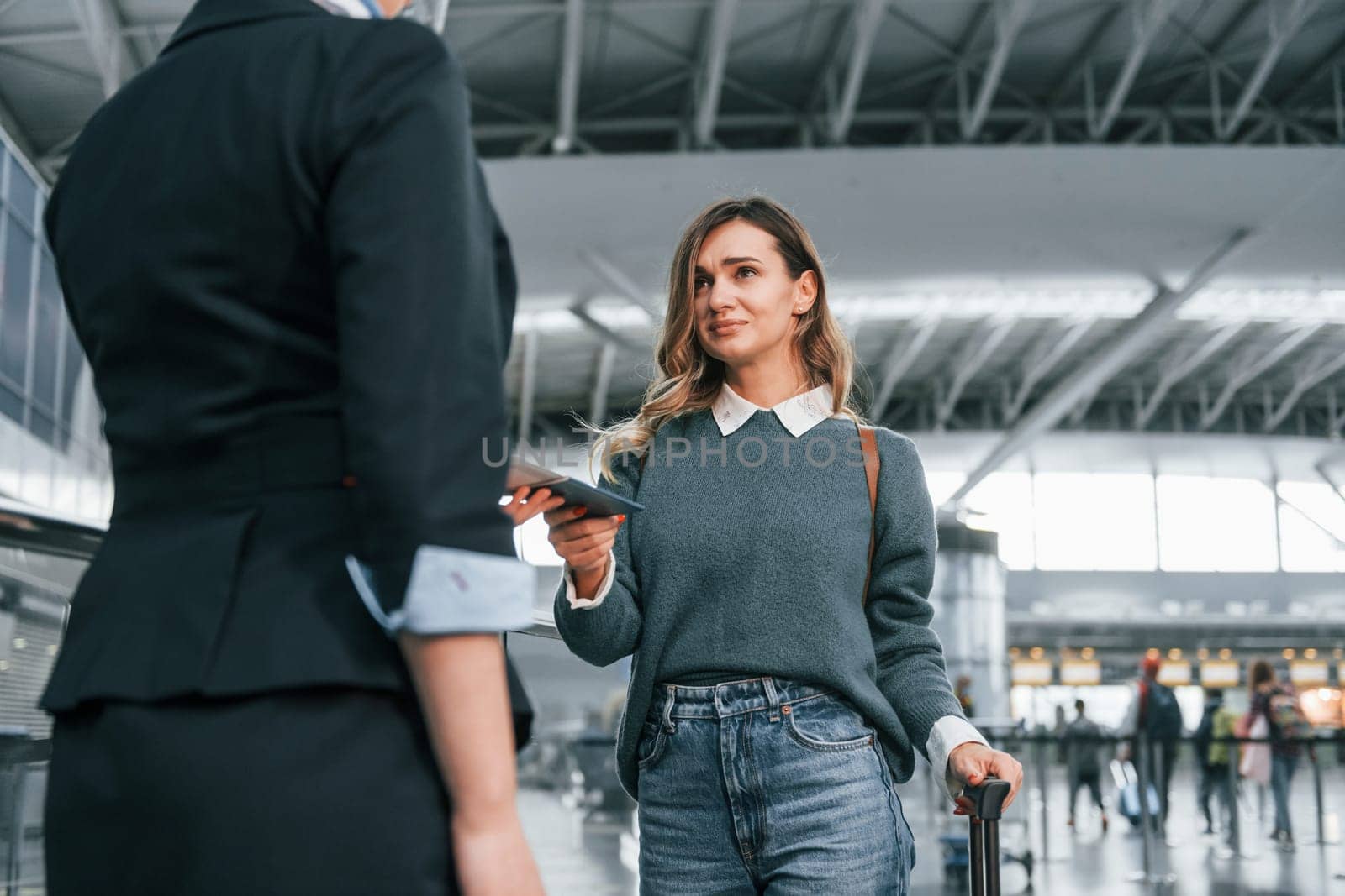 With documents. Young female tourist is in the airport at daytime.