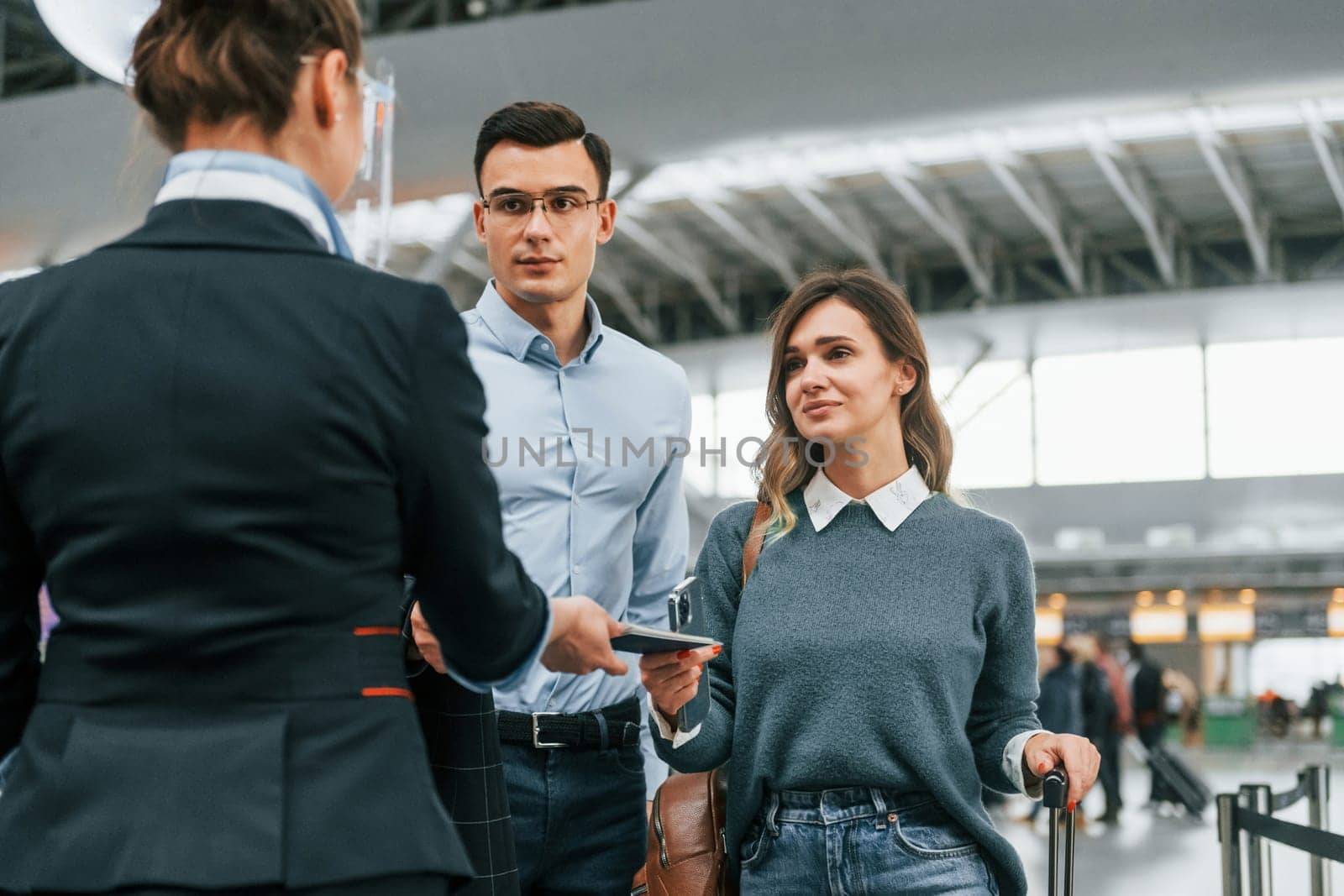 Checking documents at the entrance. Young couple is in the airport together.
