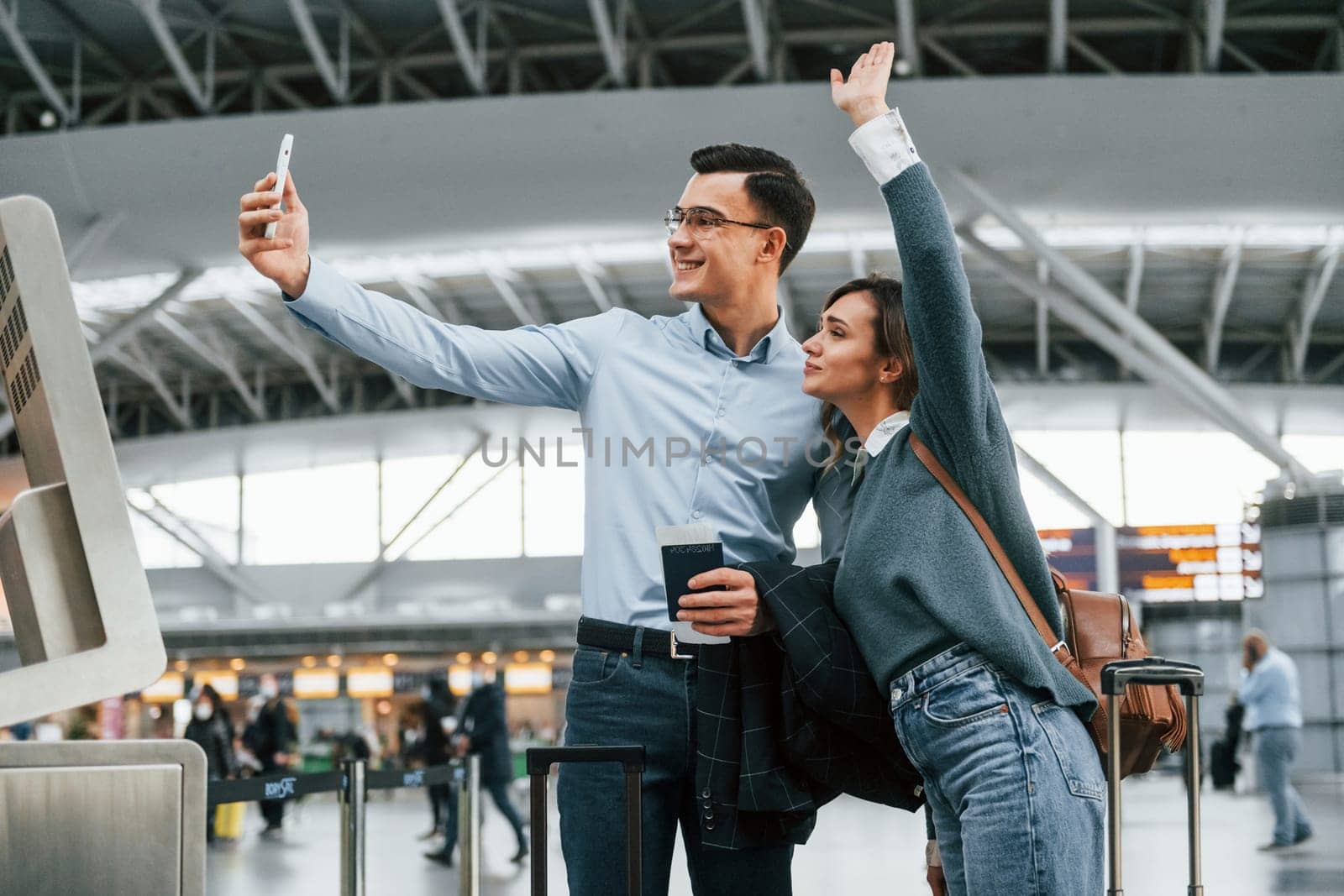Making selfie. Young couple is in the airport together by Standret