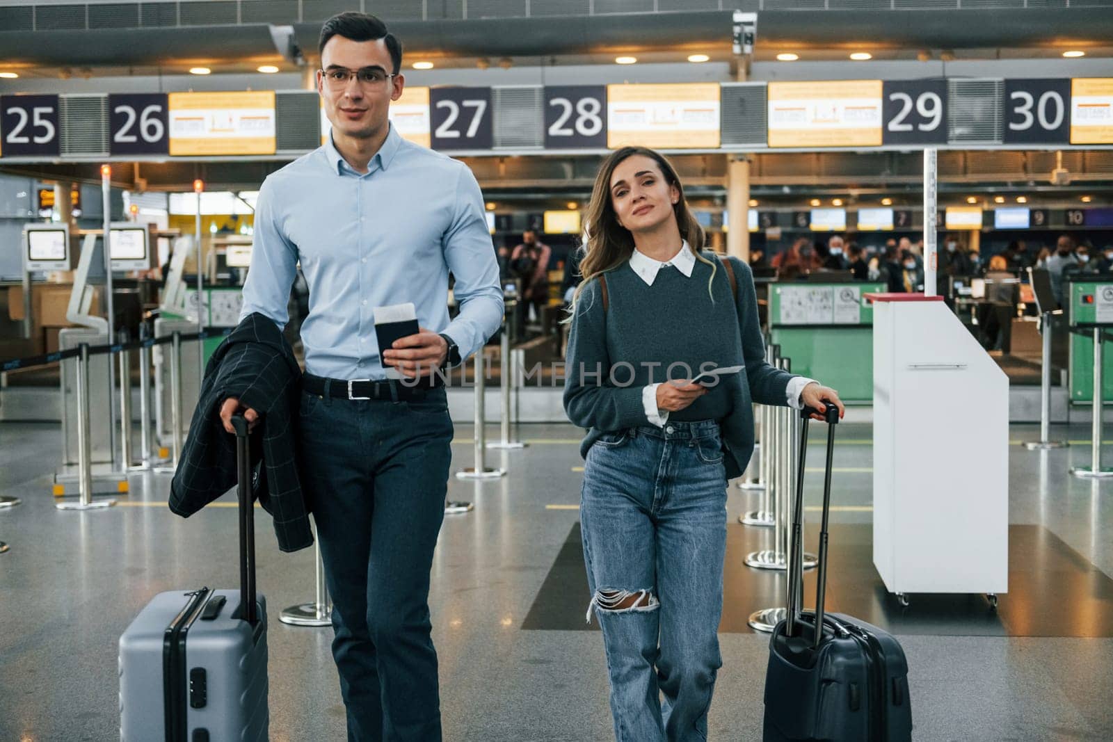 Walking forward. Young couple is in the airport together.