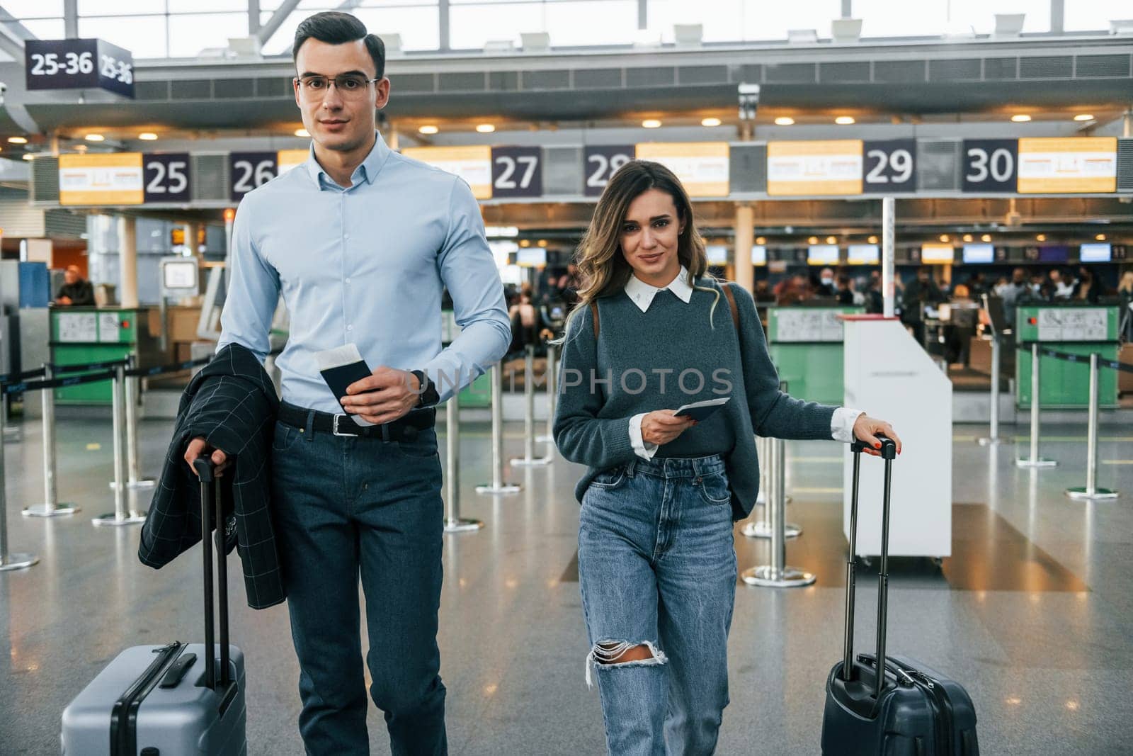 Walking forward. Young couple is in the airport together.