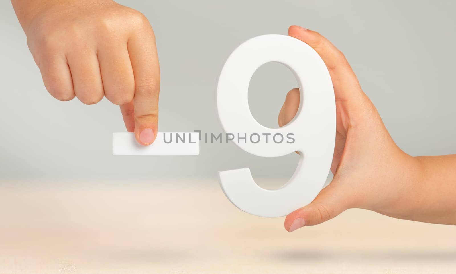 Minus nine. The number nine and the minus symbol in a hand close-up on a light gray background. The concept of removal or taking away. by SERSOL