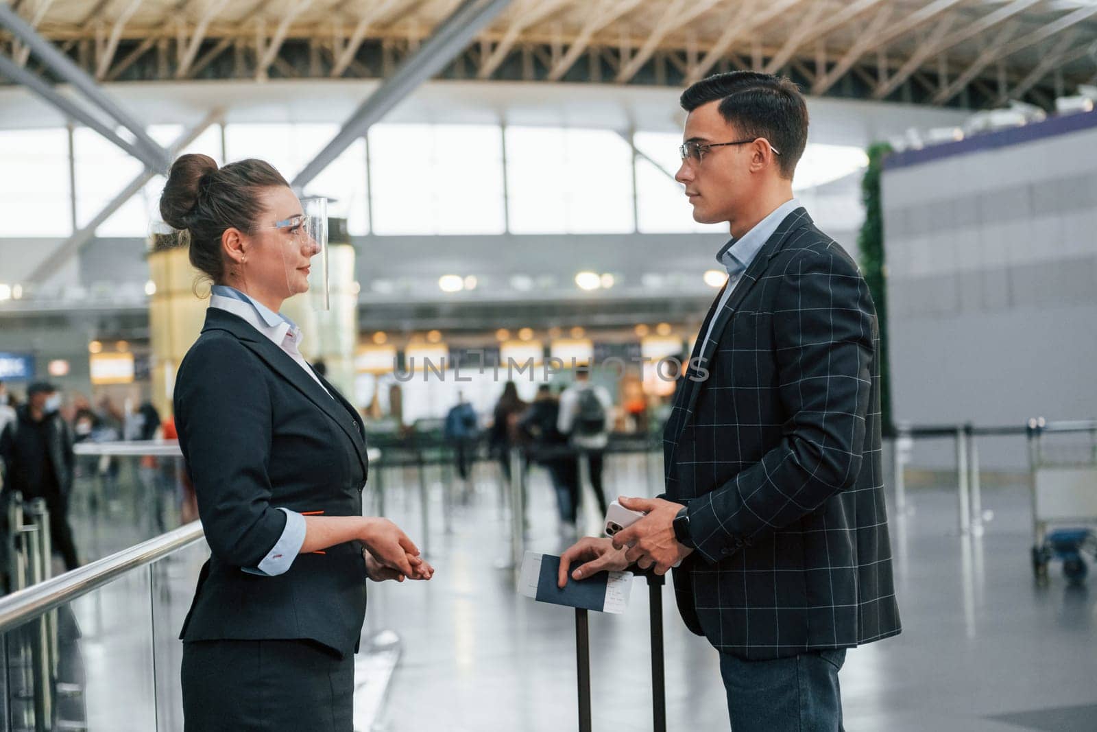 Working with documents. Young businessman in formal clothes is in the airport at daytime.