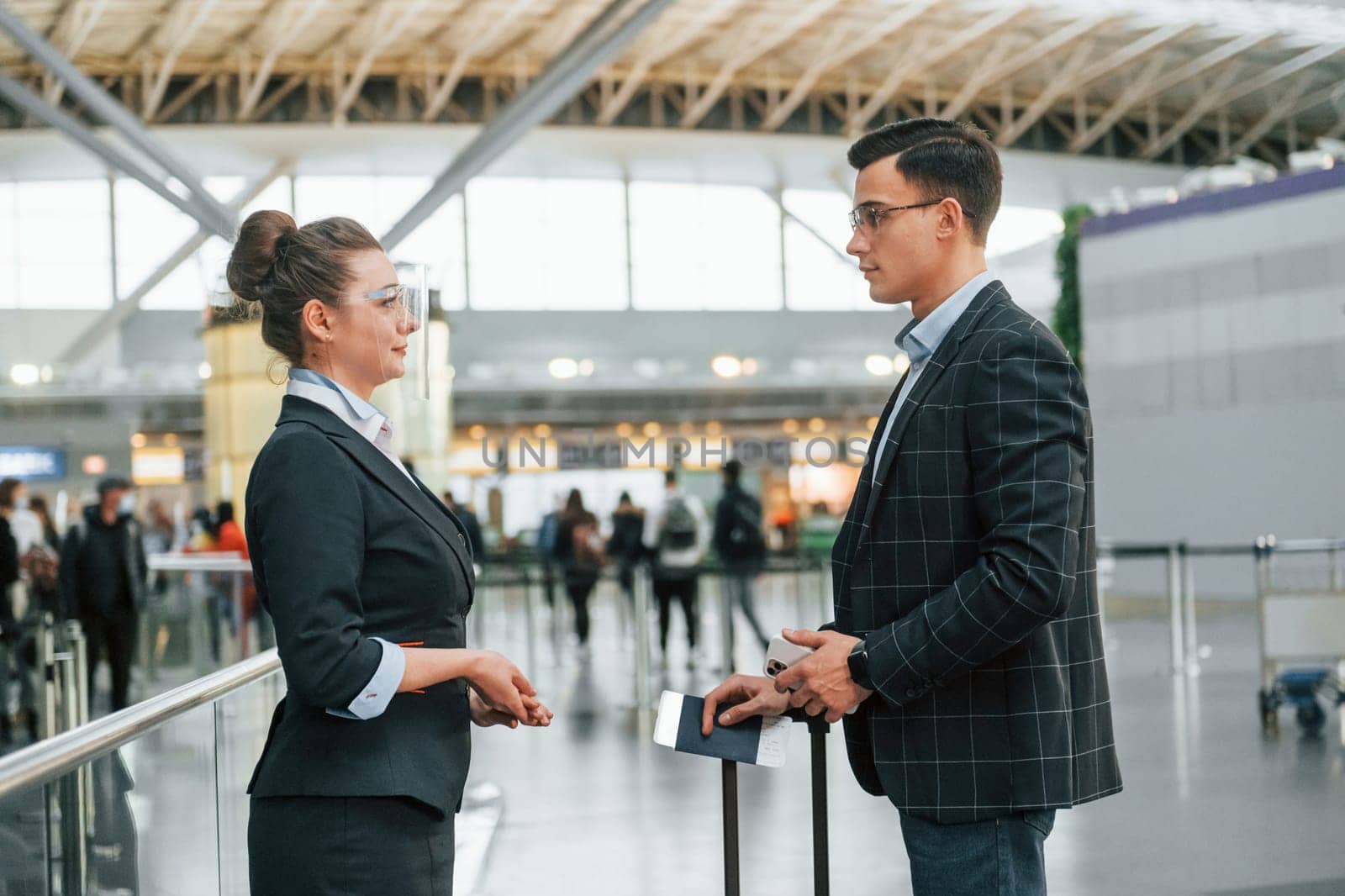 Working with documents. Young businessman in formal clothes is in the airport at daytime.