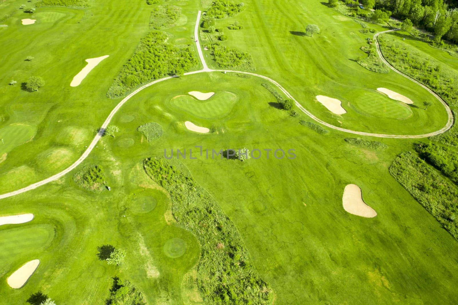 Golf course with sand bunker and green grass, aerial view.