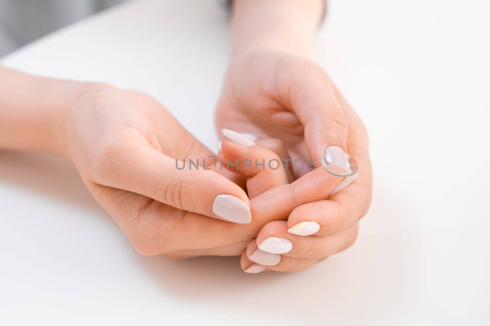 Woman holding contact lens on the finger tip