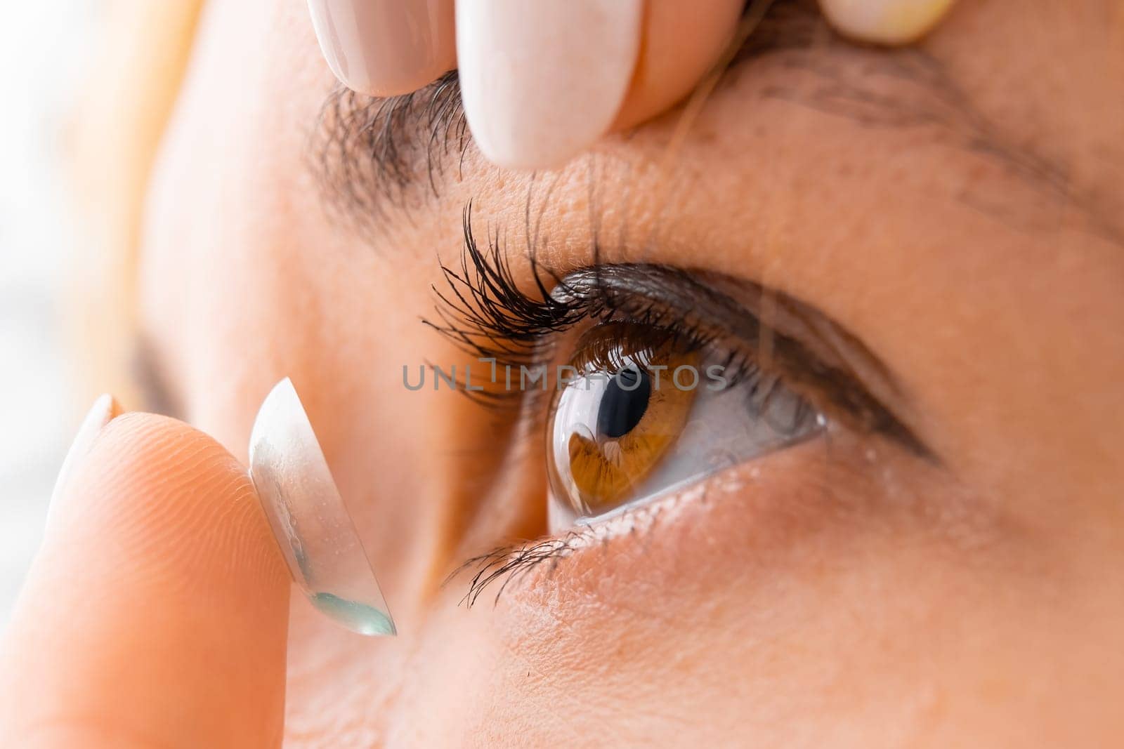 Close up woman applying contact eye lens