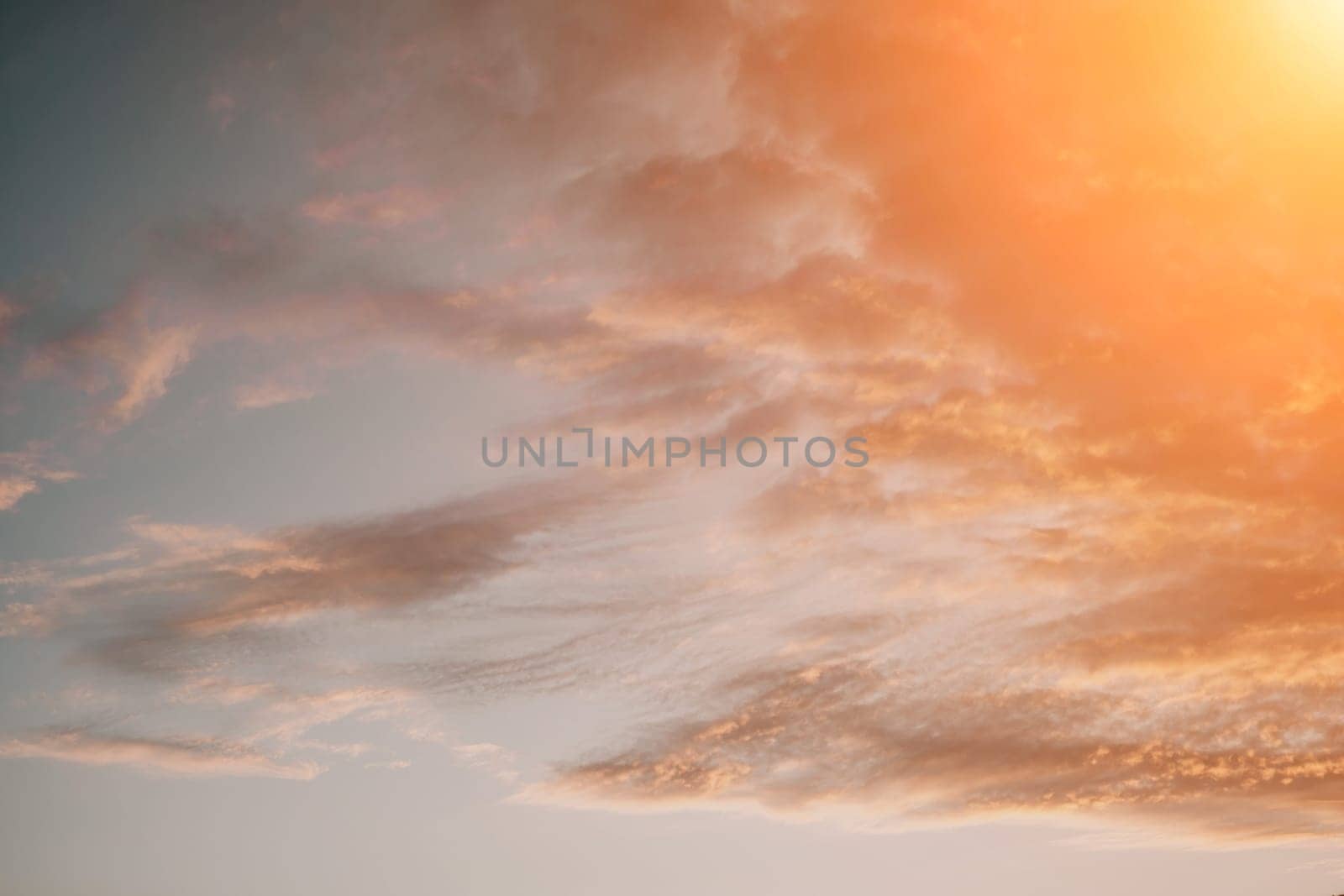 A red burning sunset over the sea with rocky volcanic cliff. Abstract nature summer ocean sea background. Small waves on golden warm water surface with bokeh lights from sun. by panophotograph