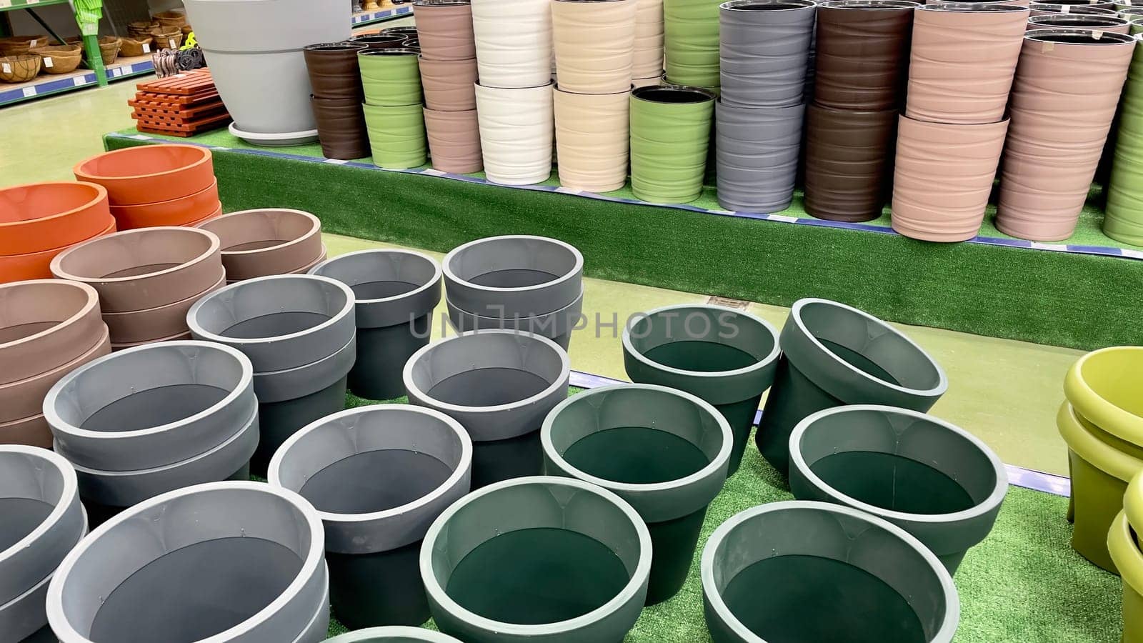 Close-up of empty flower pots in a store or greenhouse. Colorful pots for plants. Gardening and landscape design concept by Matiunina