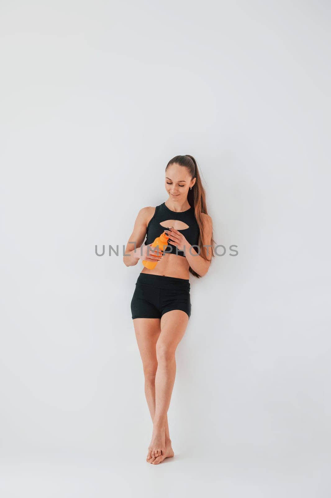 Beautiful body. Young woman in sportive clothes doing gymnastics indoors.