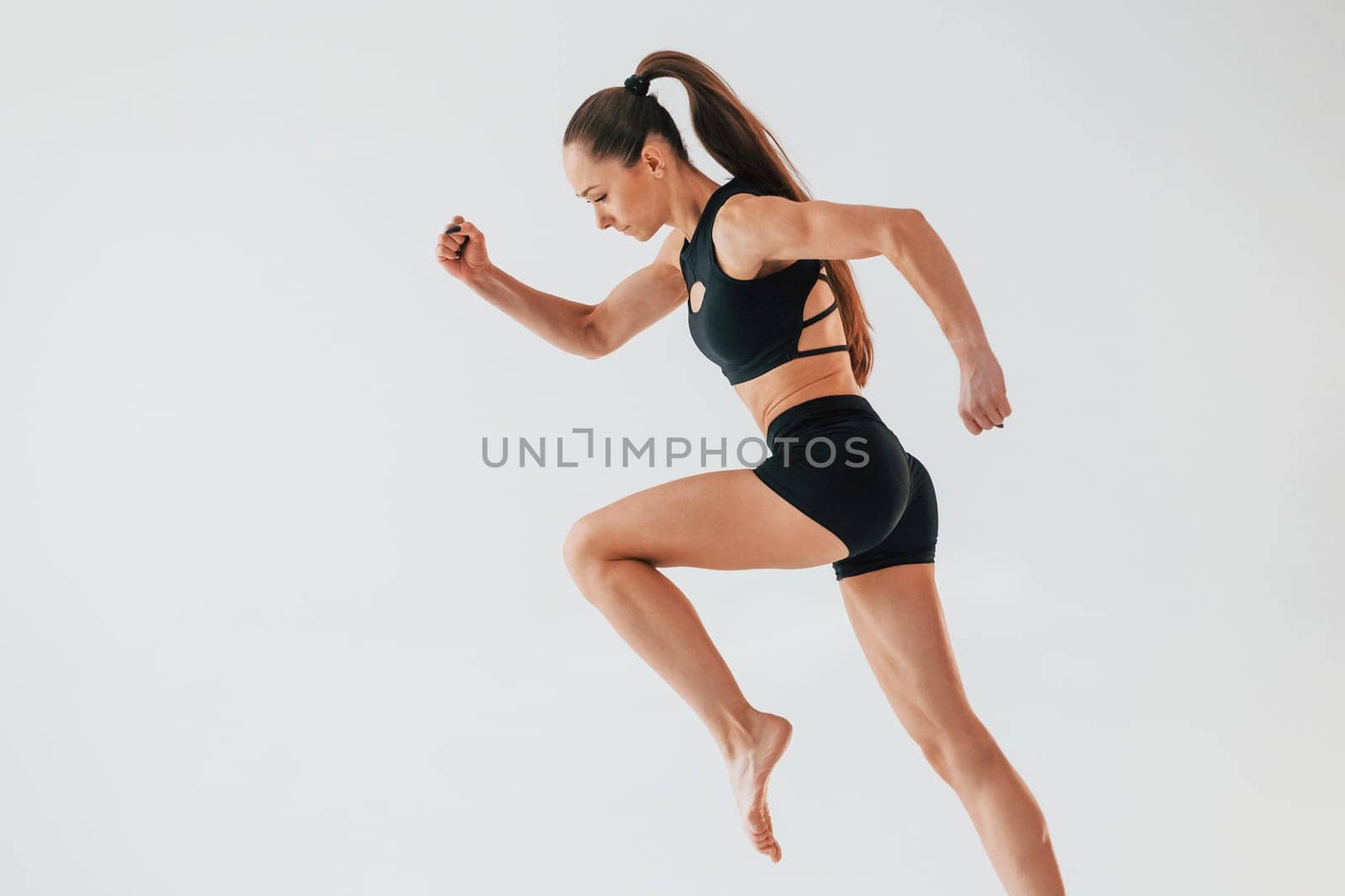 Flexibility of the body. Young woman in sportive clothes doing gymnastics indoors.