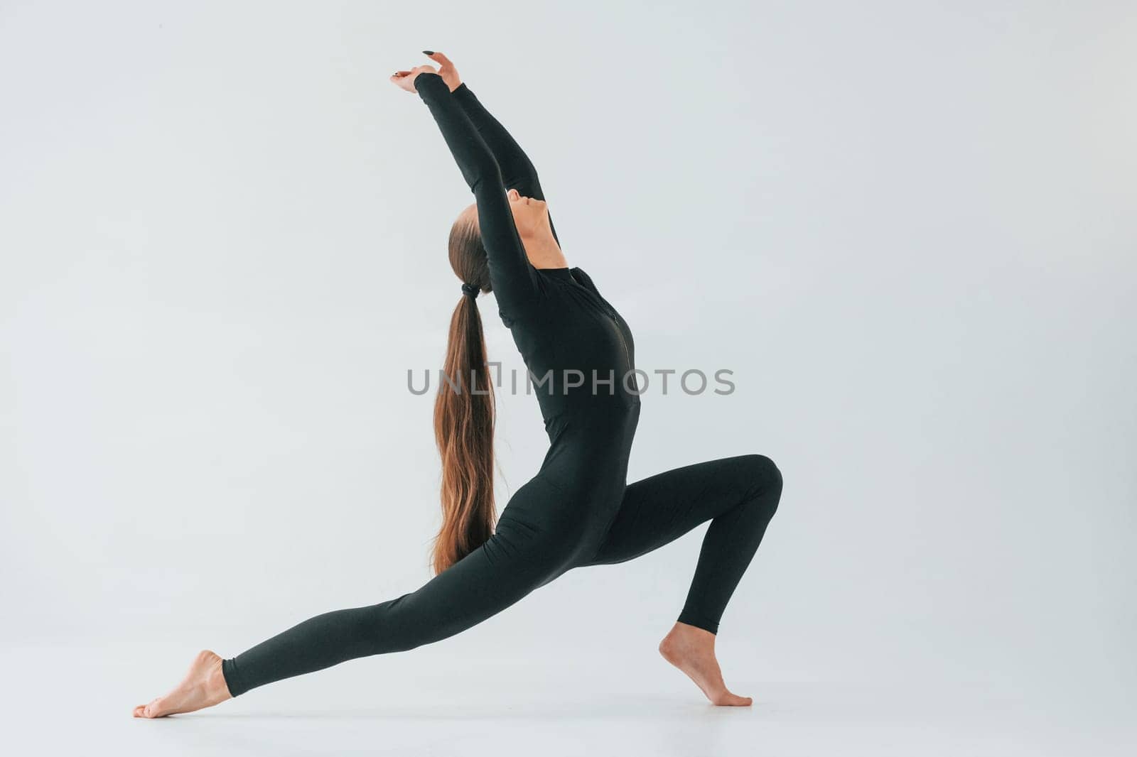 Healthy person. Young woman in sportive clothes doing gymnastics indoors.