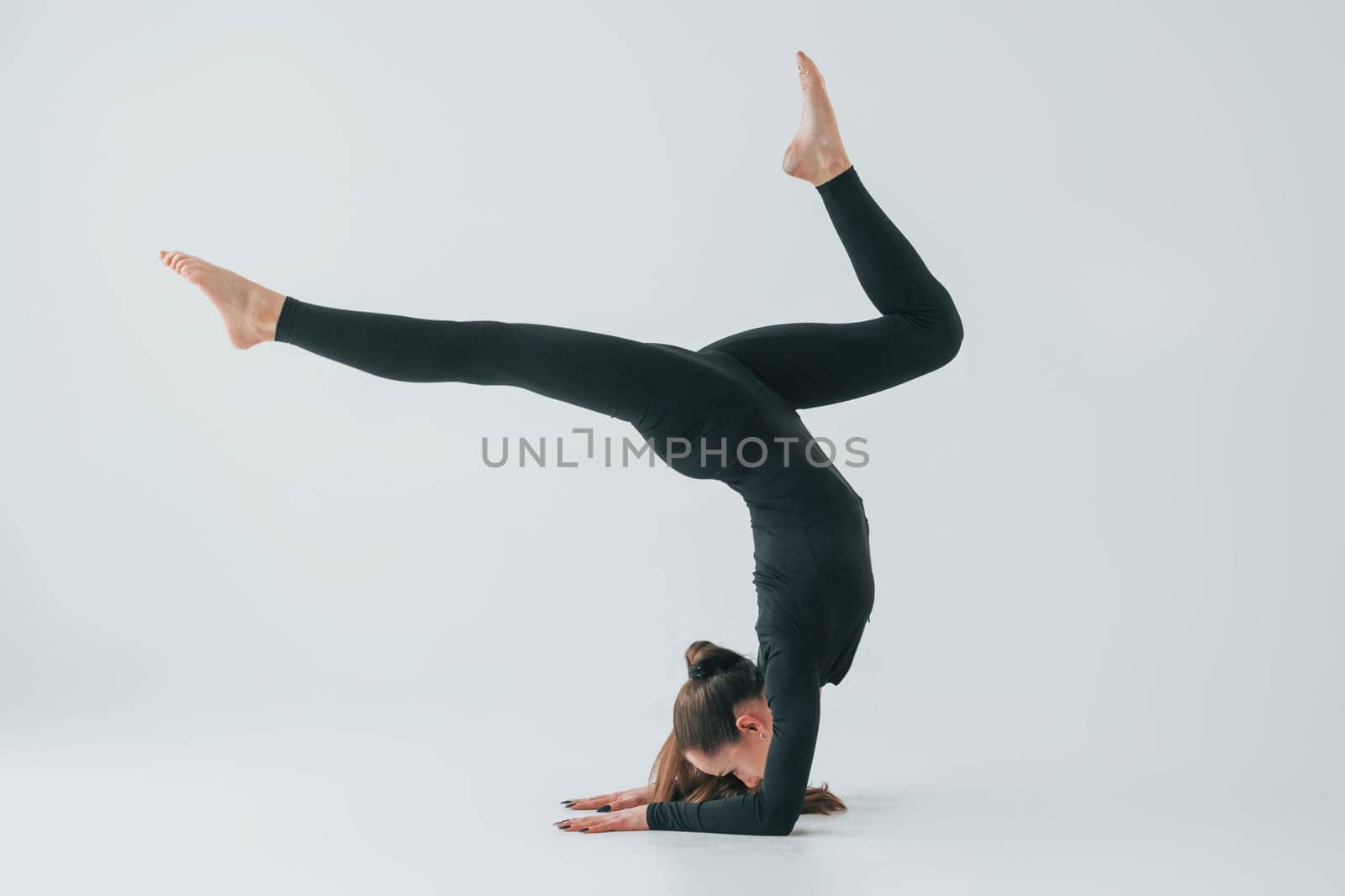 Healthy person. Young woman in sportive clothes doing gymnastics indoors.