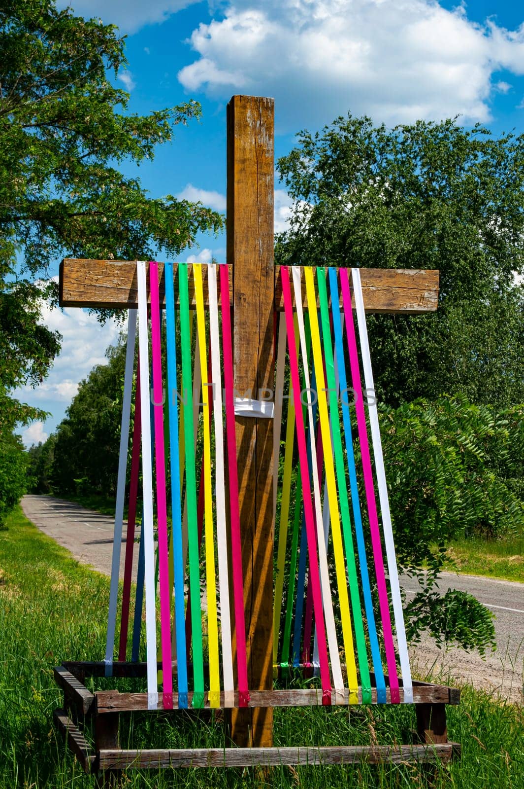 The Christian cross is decorated with ribbons of rainbow colors. Christian cross. Easter decoration. Religion and culture. Orthodoxy, Catholicism, Protestantism. Ukrainian Orthodox Church.