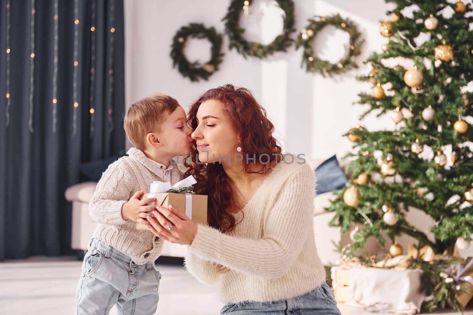 Mother with her little son is at home. Christmas decorations.