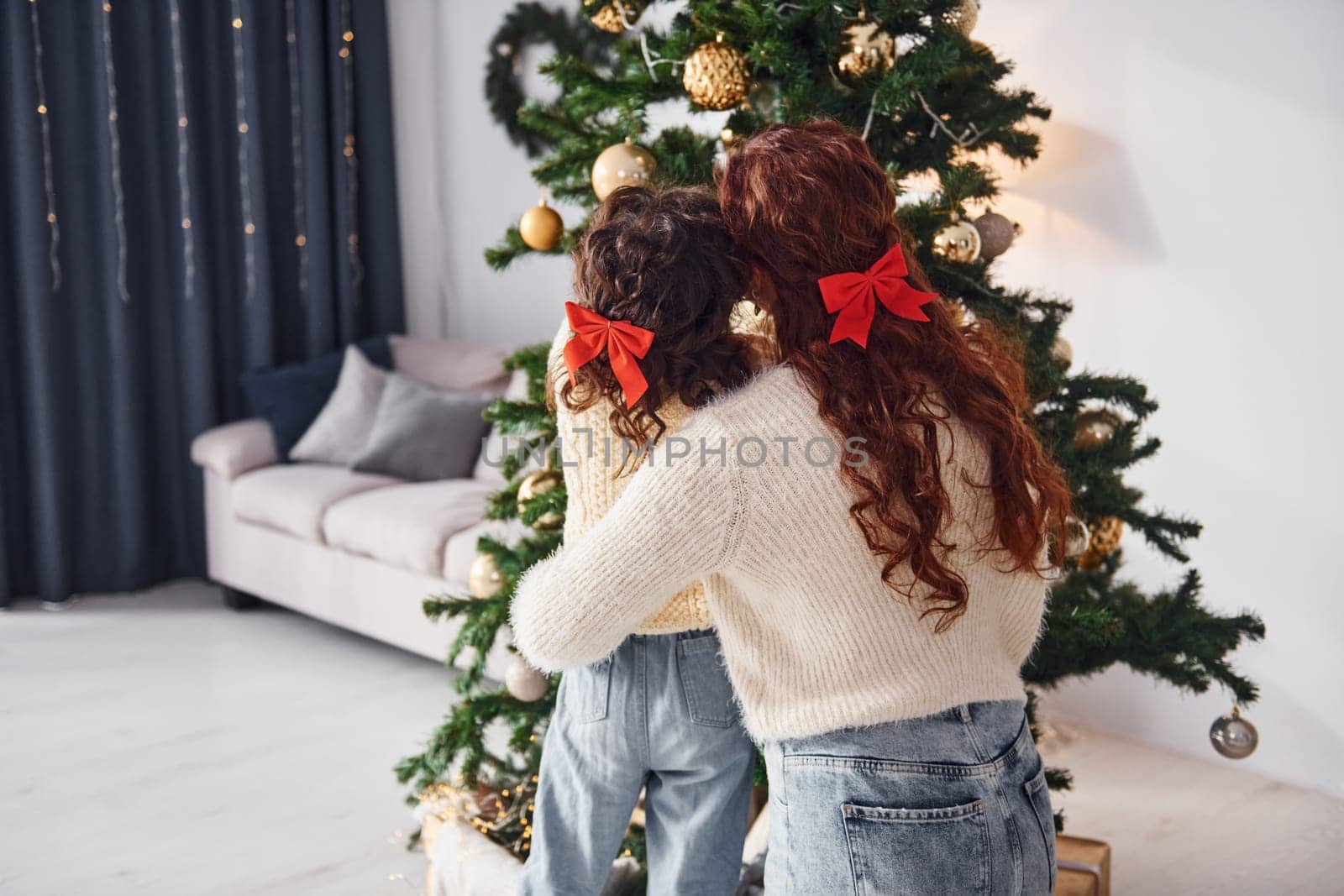 Decorating tree. Mother with her little daughter is at home.