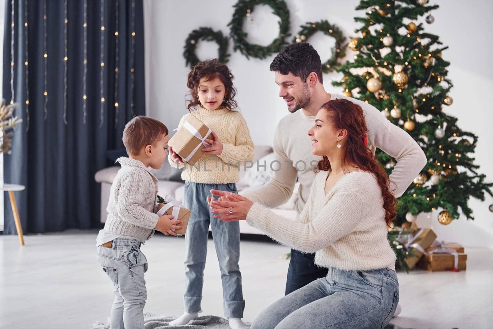With gift boxes. Family celebrating new year with their children at home.