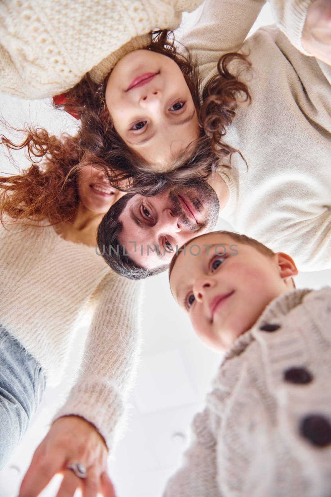 View from below. Happy family looking down and having fun.