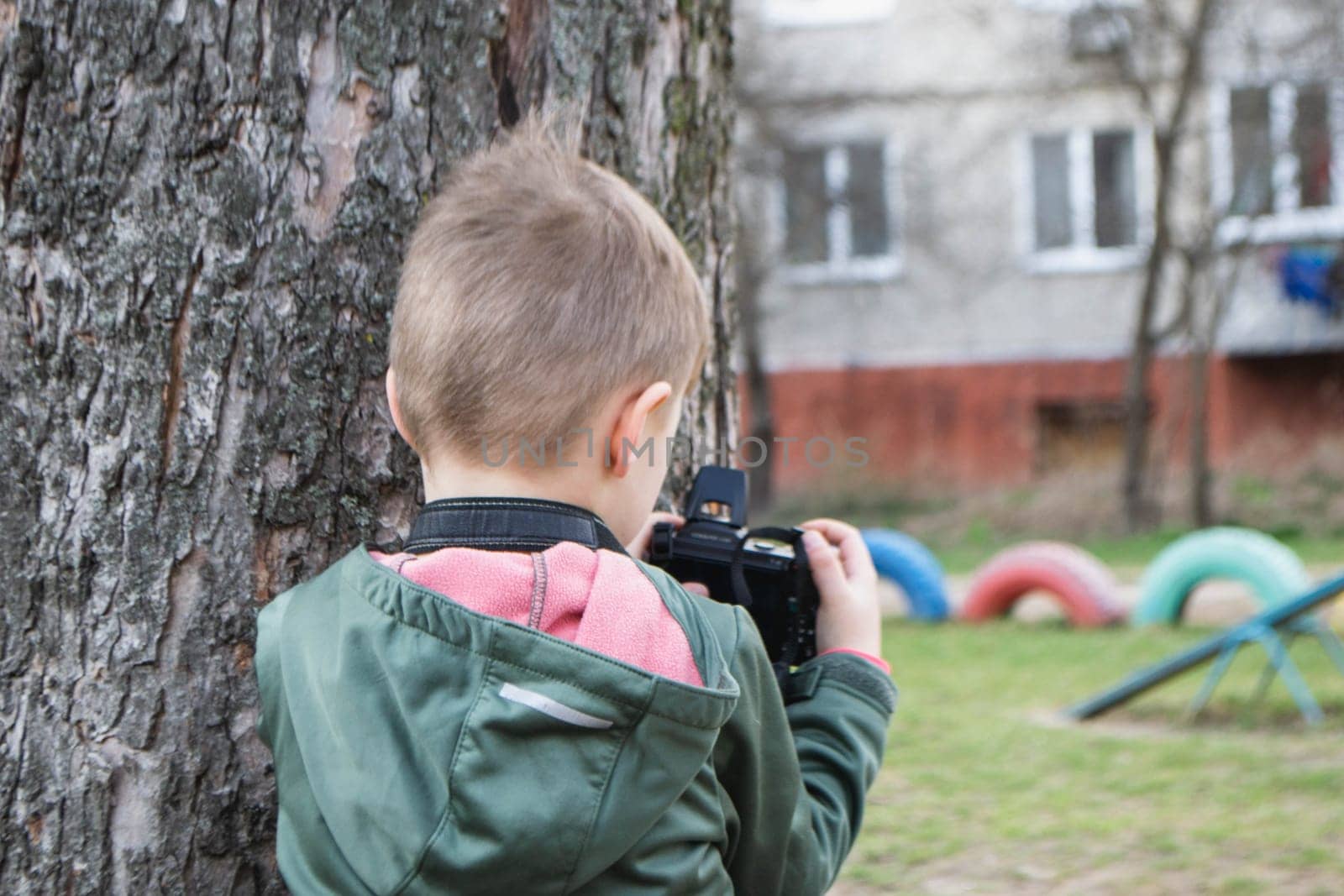 kid on the street in a jacket with an film camera. High quality photo