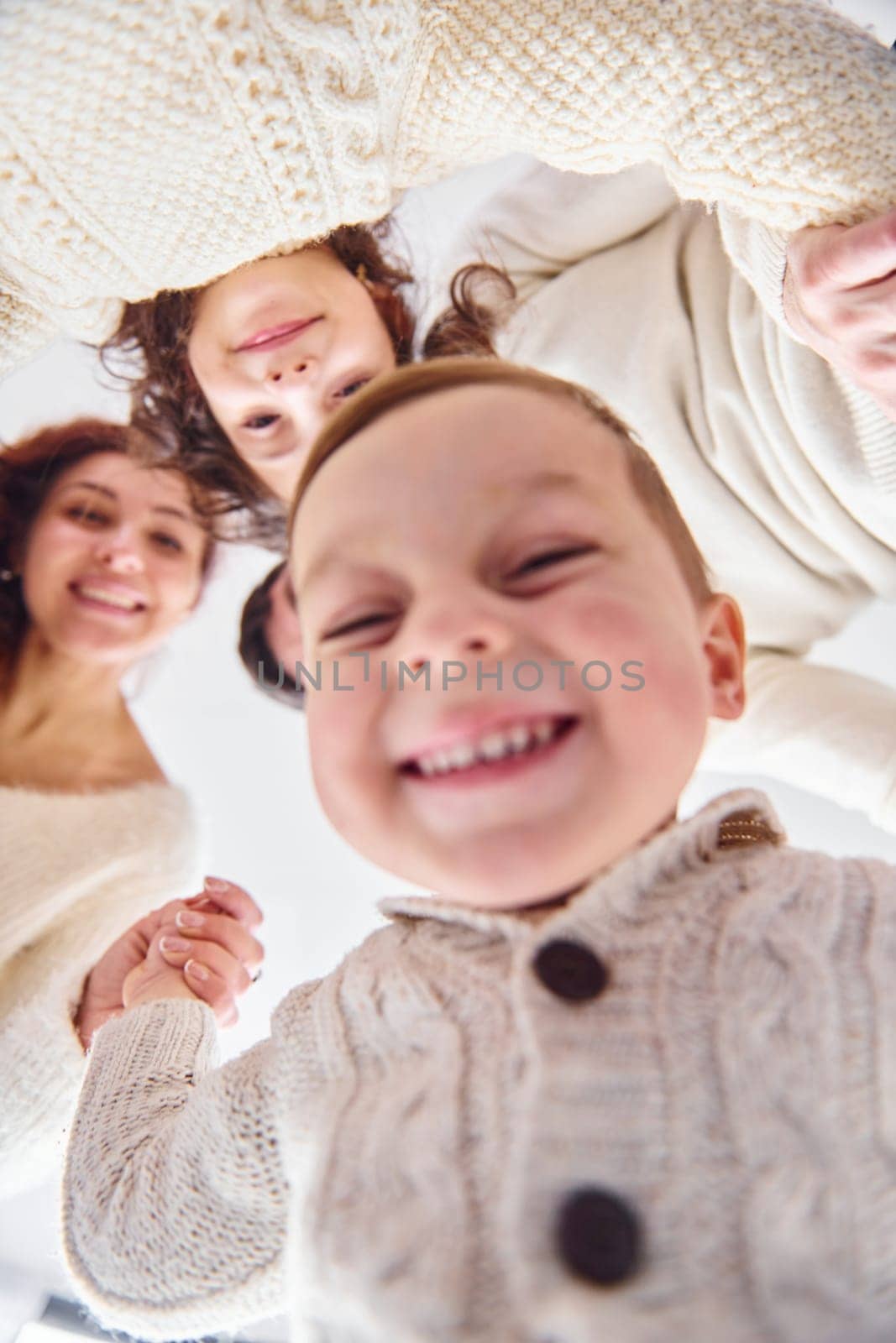 Smiling and having fun. View from below. Happy family looking down.