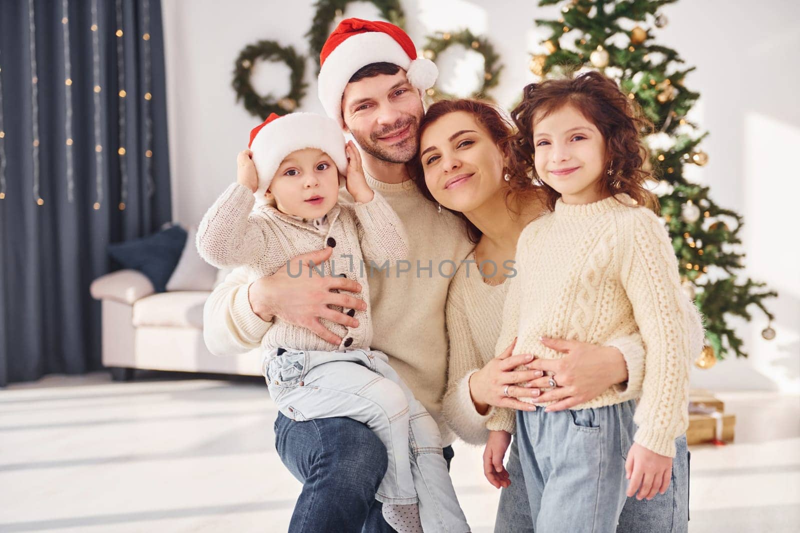 In christmas hats. Family celebrating new year with their children at home.