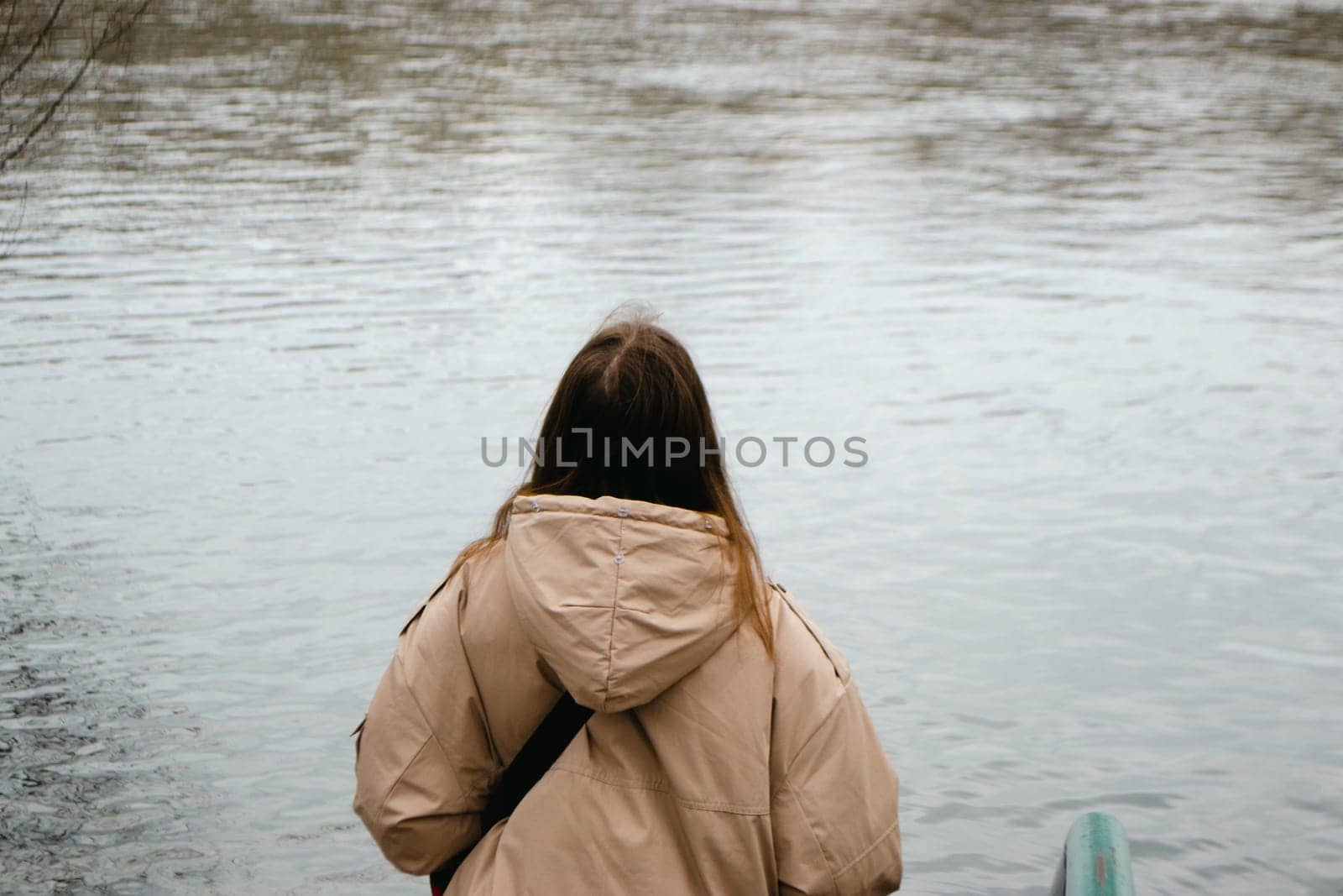 A woman with long brown hair near river in spring. High quality photo