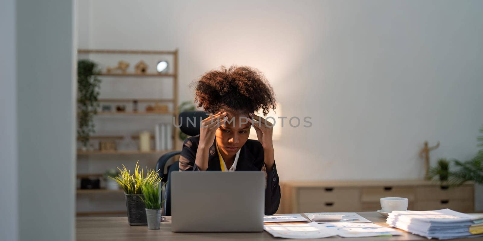Stress, anxiety and burnout with a business black woman at work using a laptop while suffering from a headache. Compliance, computer and mental health with a female employee struggling on a deadline by nateemee