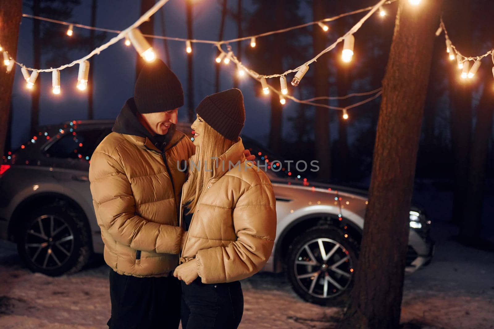 Embracing each other. Couple standing in the forest and celebrating New year.
