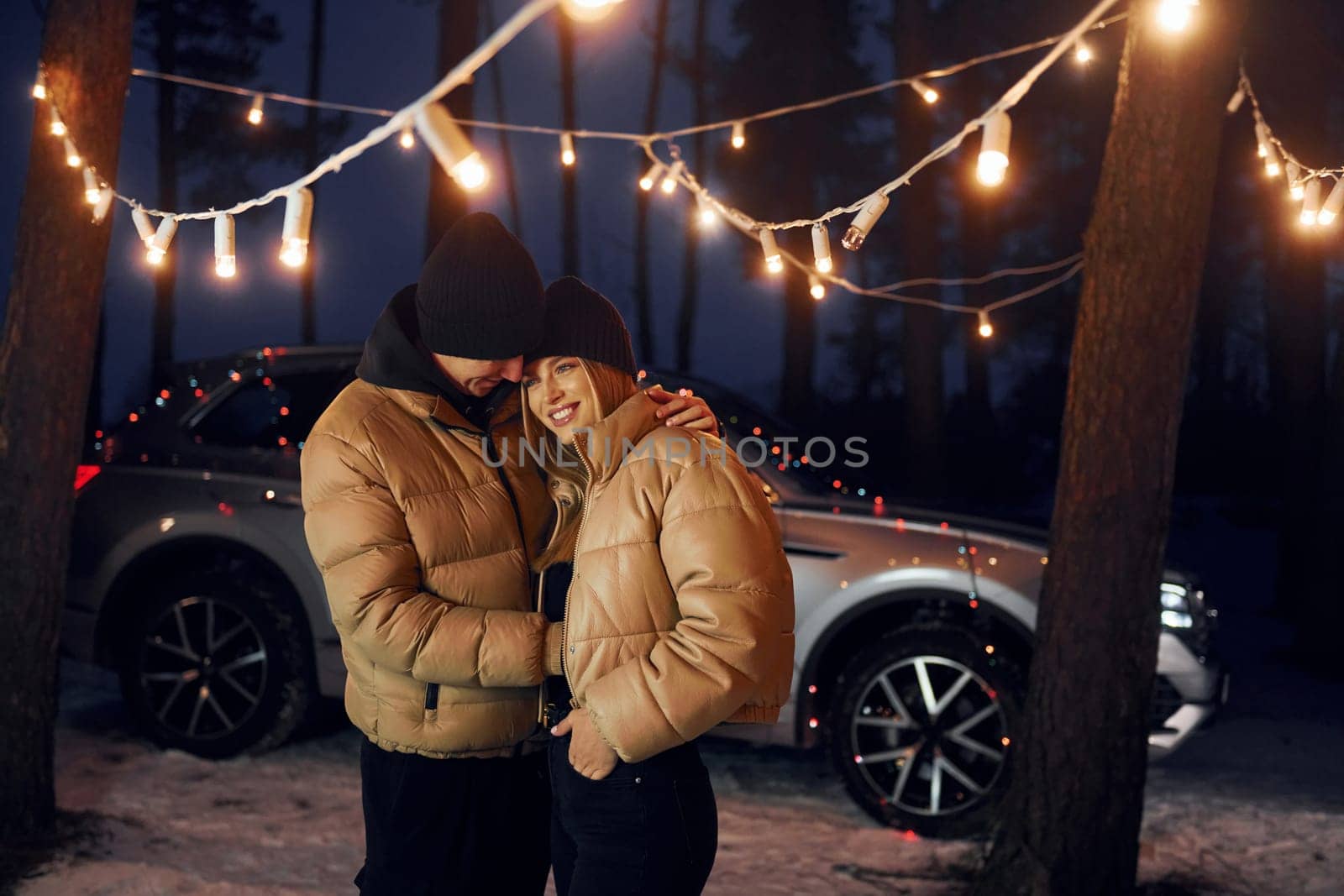 Embracing each other. Couple standing in the forest and celebrating New year.