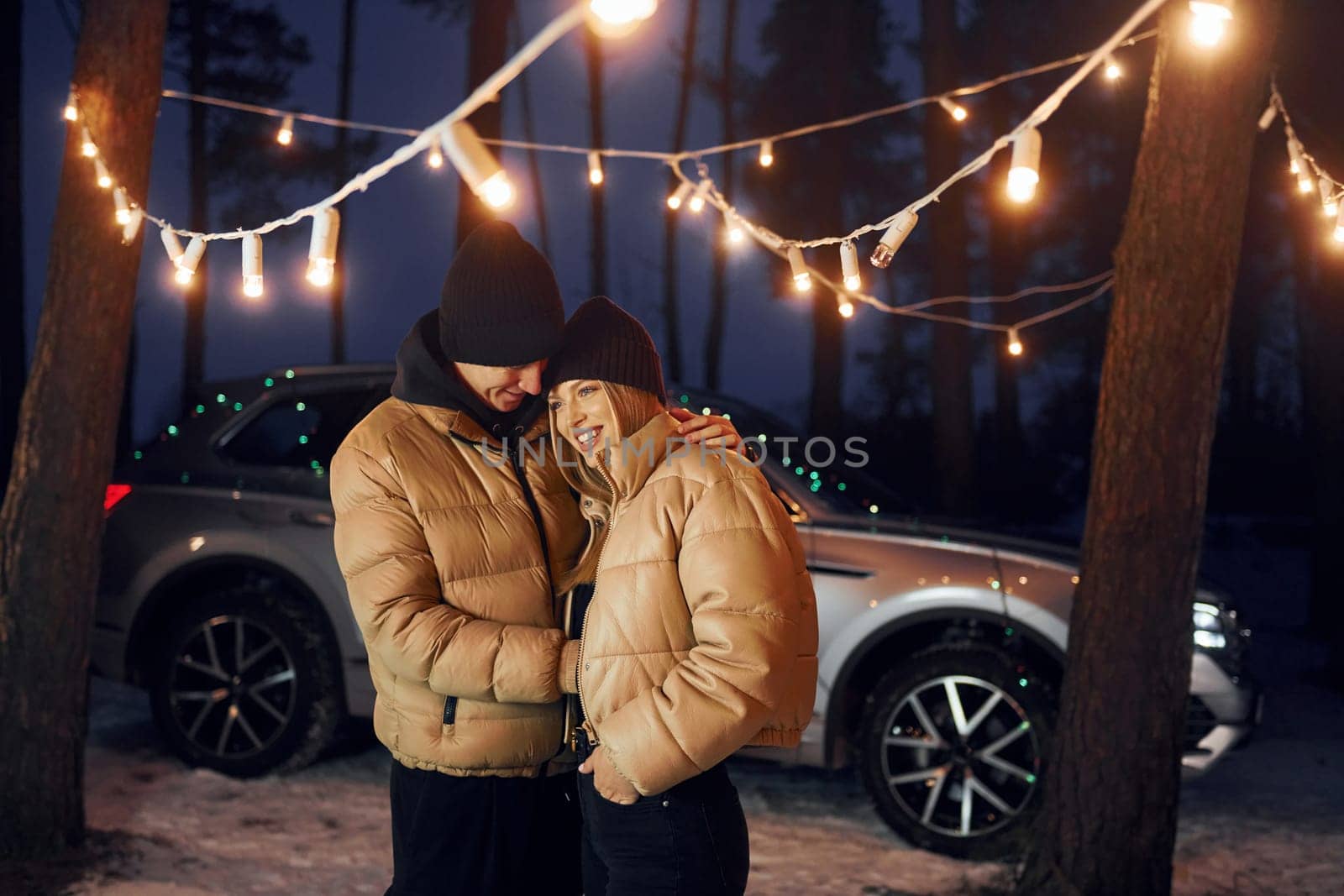 Embracing each other. Couple standing in the forest and celebrating New year.