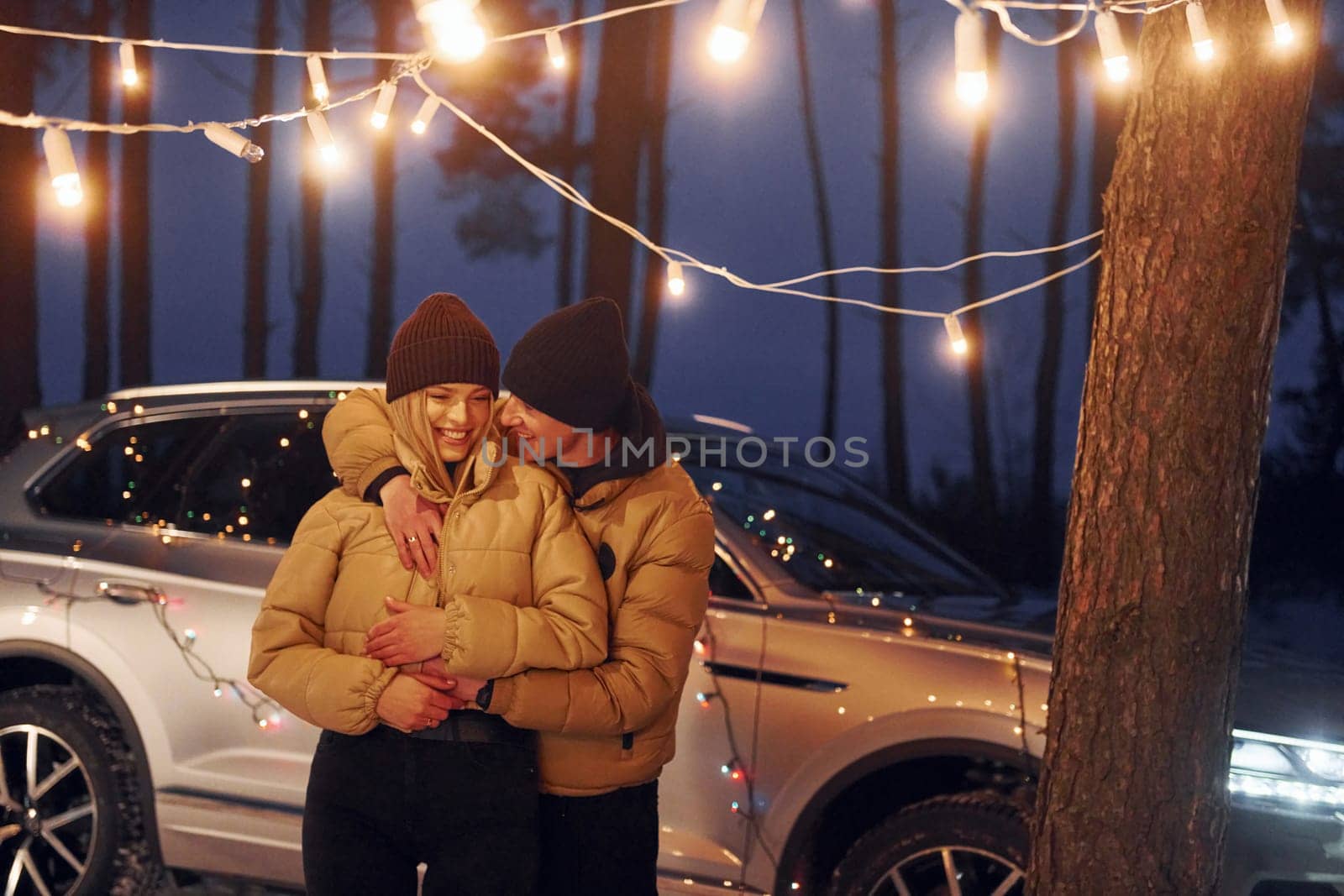 Embracing each other. Couple standing in the forest and celebrating New year.